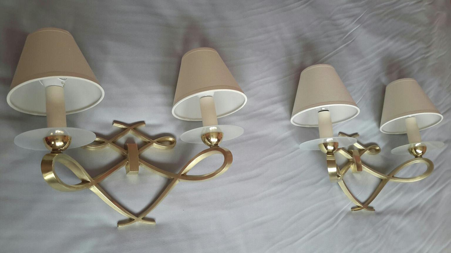 Very elegant pair of French neoclassical mid-1950s double sconces in polished gilted bronze nicely decorated with frosted glass discs ornements.
By Arlus in the style of Jules Leleu.
The pair is in a very good original condition, the electric part