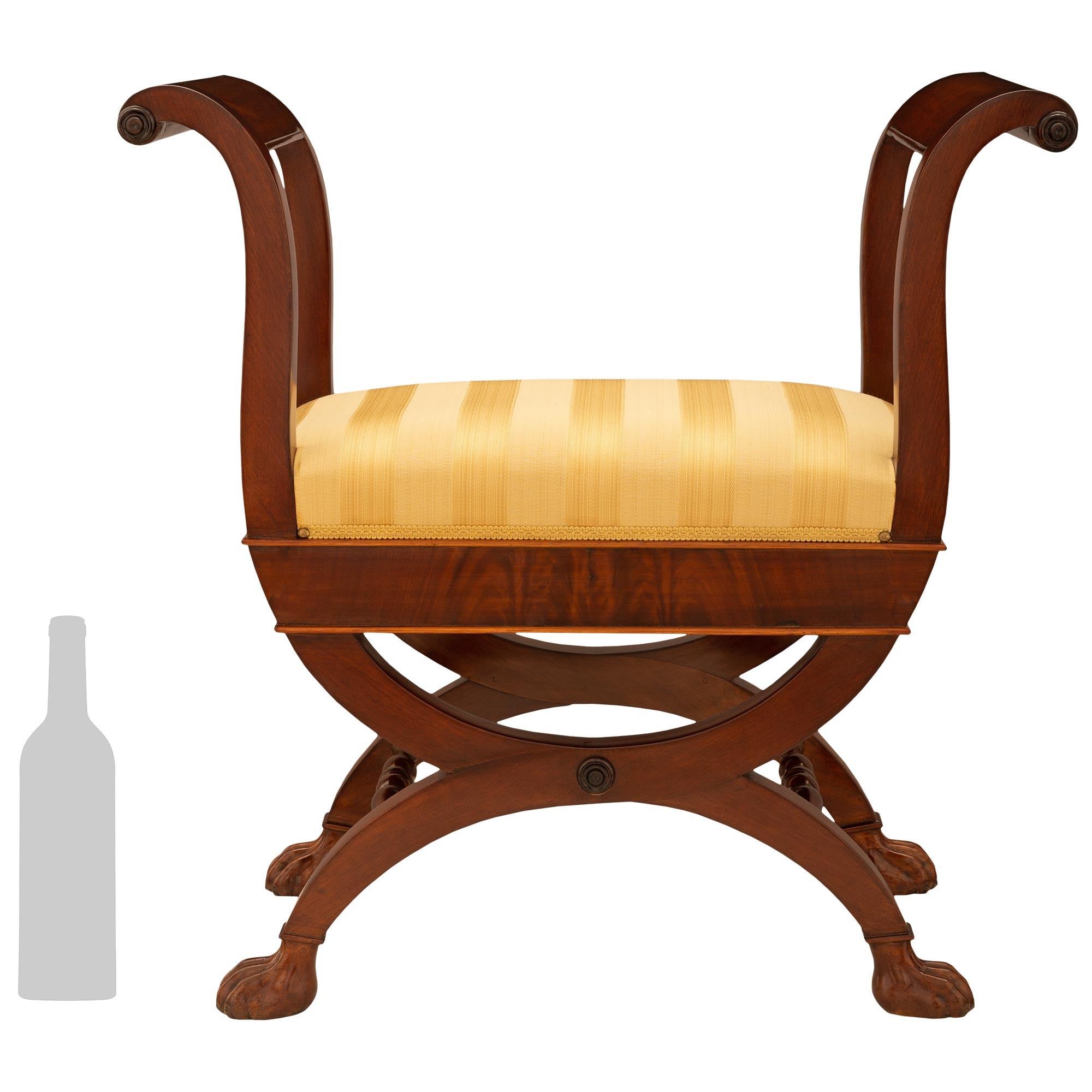Una bella coppia di panche in mogano di stile Impero francese dell'inizio del XIX secolo, di alta qualità. Ogni panca è sollevata da gambe quadrate ricurve e sostenuta da piedi a zampa collegati da due barelle tornite. I grembiuli dritti sono