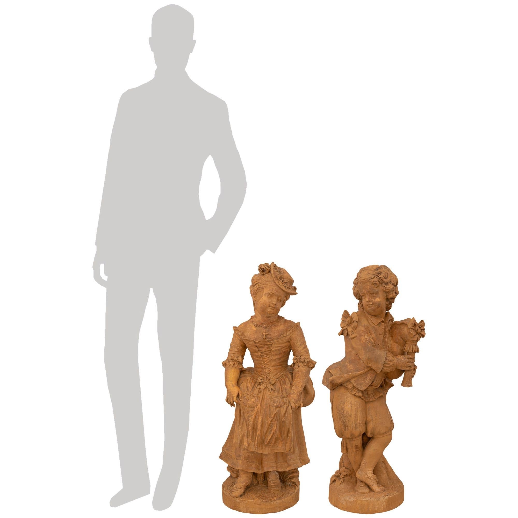 Una meravigliosa e affascinante coppia di statue in terracotta francesi dell'inizio del XIX secolo, circa 1820. Ogni statua poggia su una base circolare in terracotta che presenta una superficie simile al terreno e incisioni di corteccia d'albero,