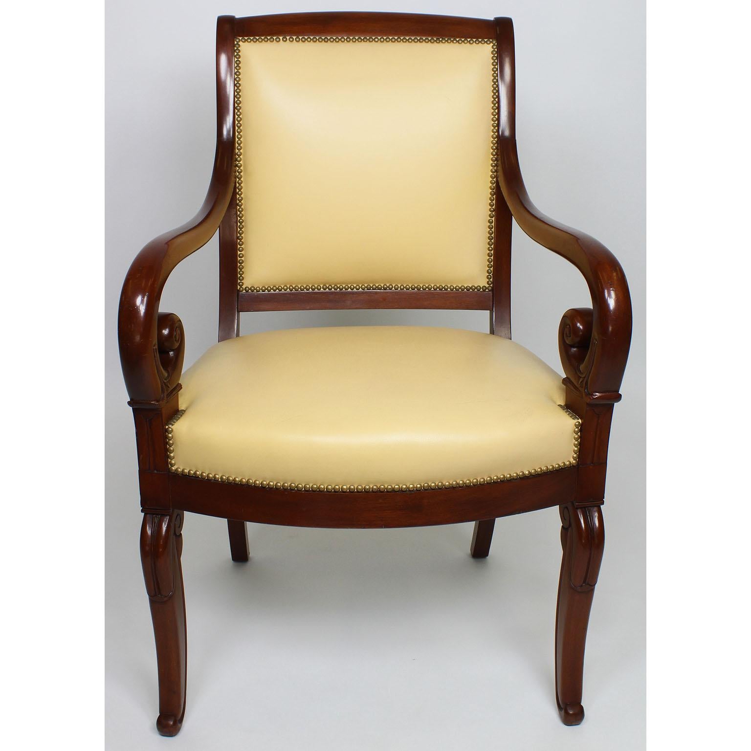 A fine pair of French early 20th century Regency style mahogany carved armchairs, each upholstered in a light cream color pleather, Paris, circa 1920s.

Measures: Height 38 3/4 inches (98.4 cm)
Width 24 3/4 inches (62.9 cm)
Depth 24 1/4 inches