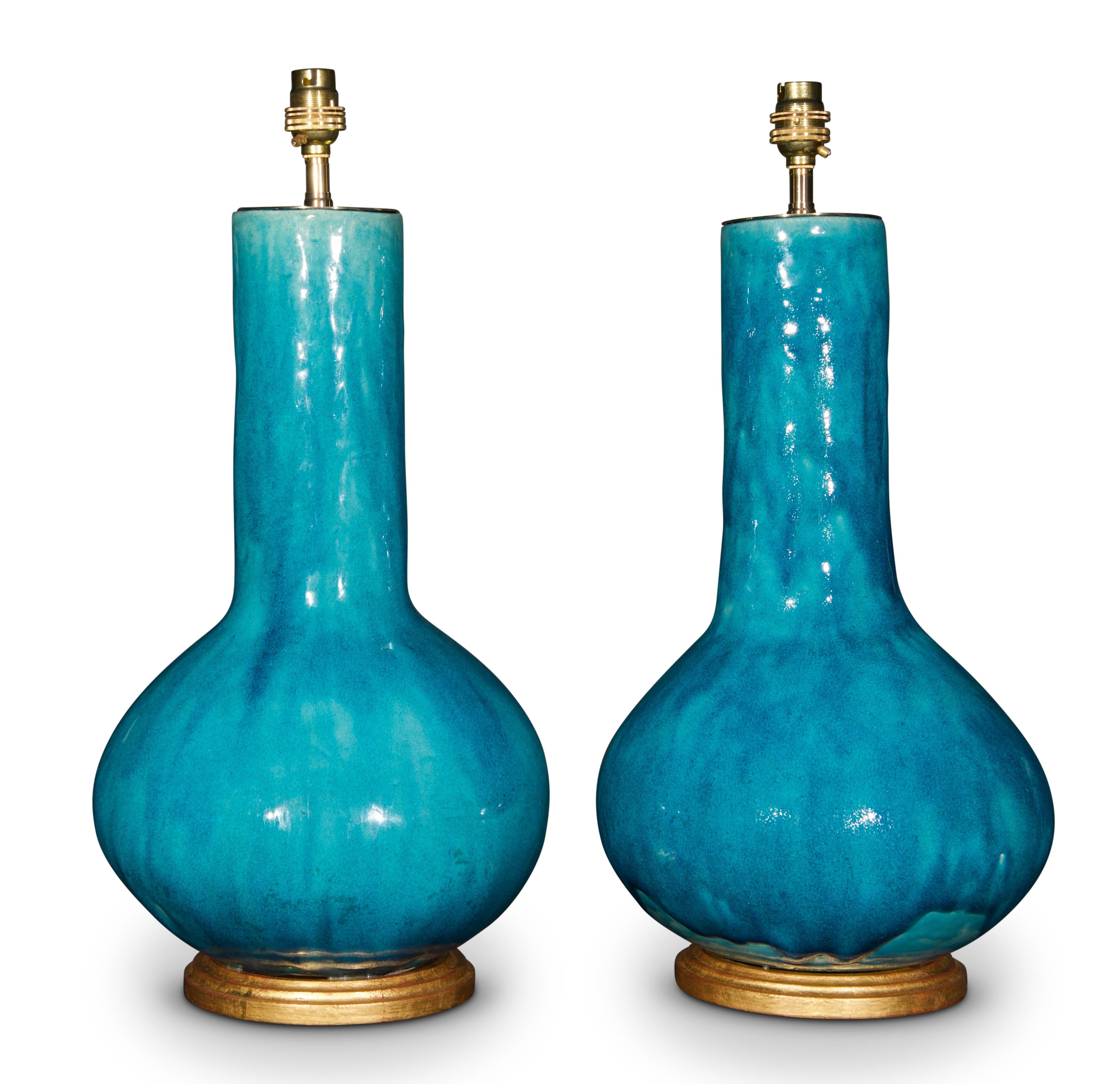 A superb pair of early 20th century French turquoise glazed ceramic vases, now mounted as lamps with hand gilded turned bases.
Fantastic colour to the glaze.

Height of vases: 16 3/4 in (43 cm) including giltwood base, exluding electrical fitment