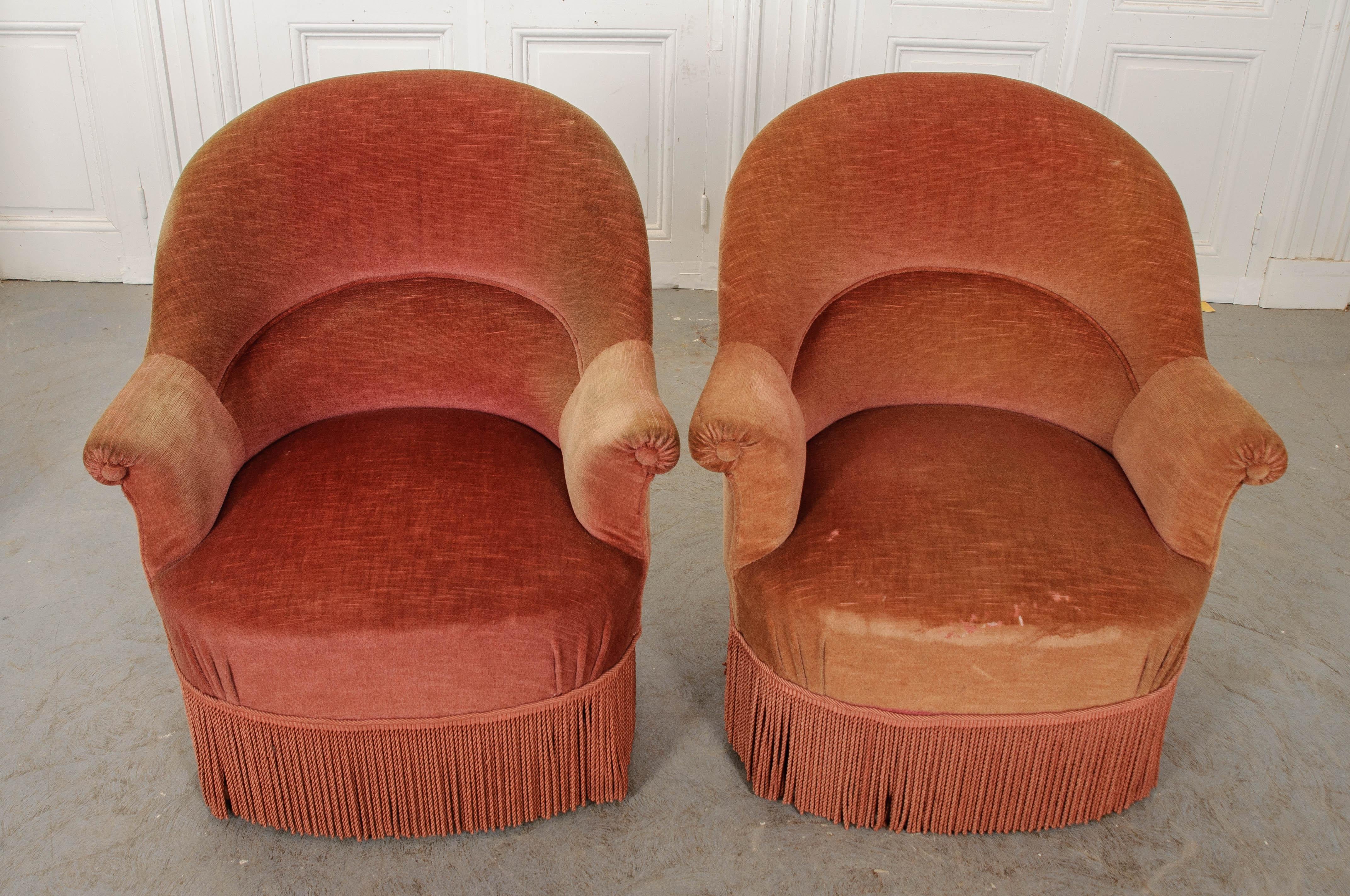 A sophisticated and smart silhouette is cast by this wonderful pair of upholstered tub chairs from 1900s France. The chairs feature barreled backs, with lines that continue to the rolled arms which are splayed for easy egress and a relaxed sitting