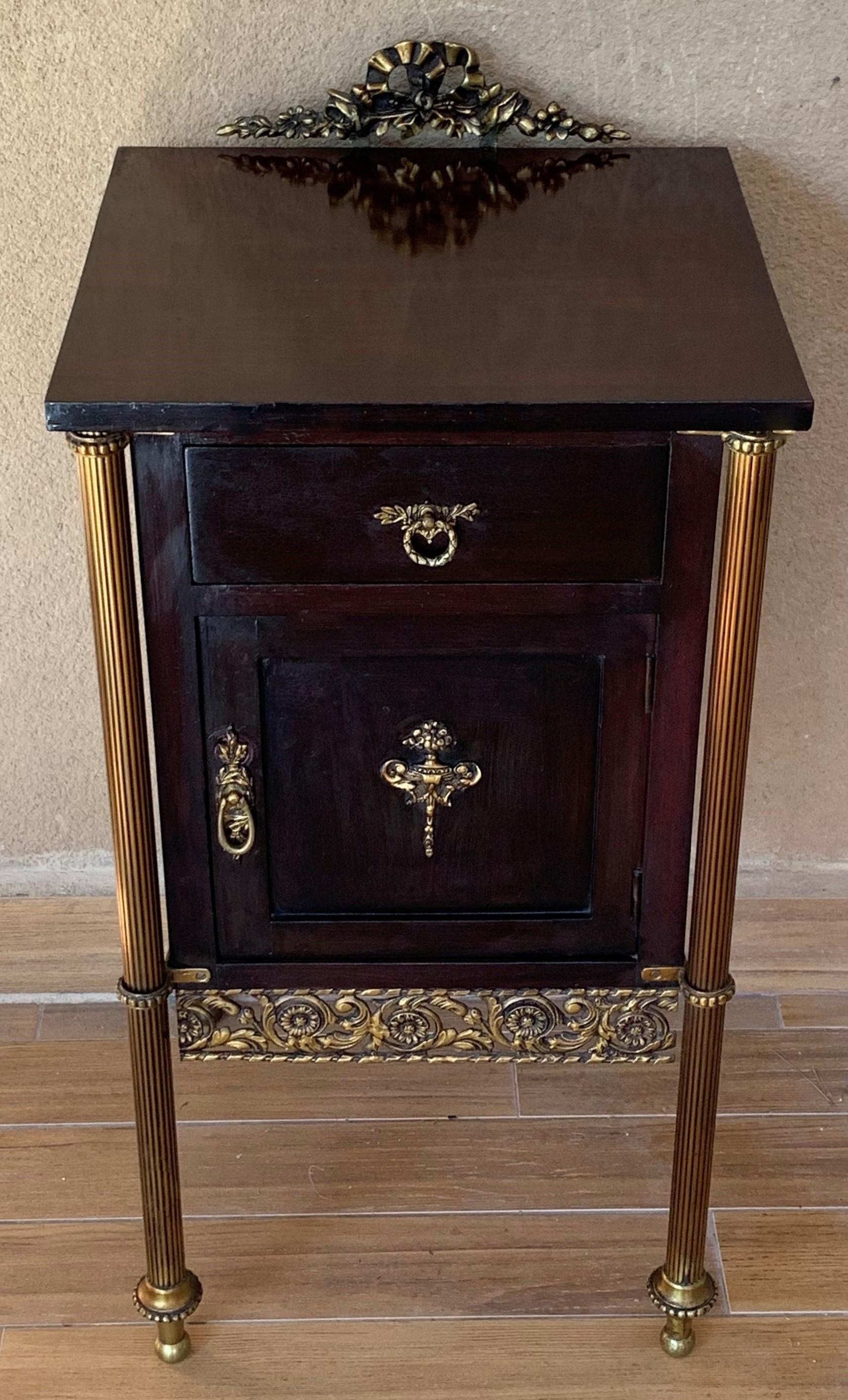 Elegant, timeless pair of French modern neoclassical ebonized mahogany with 1 drawer and 1 door. You can use like an end or side Tables. In style of Maison Jansen, each having brilliant top with crest and trimmed with a bronze gallery, circa 1940.