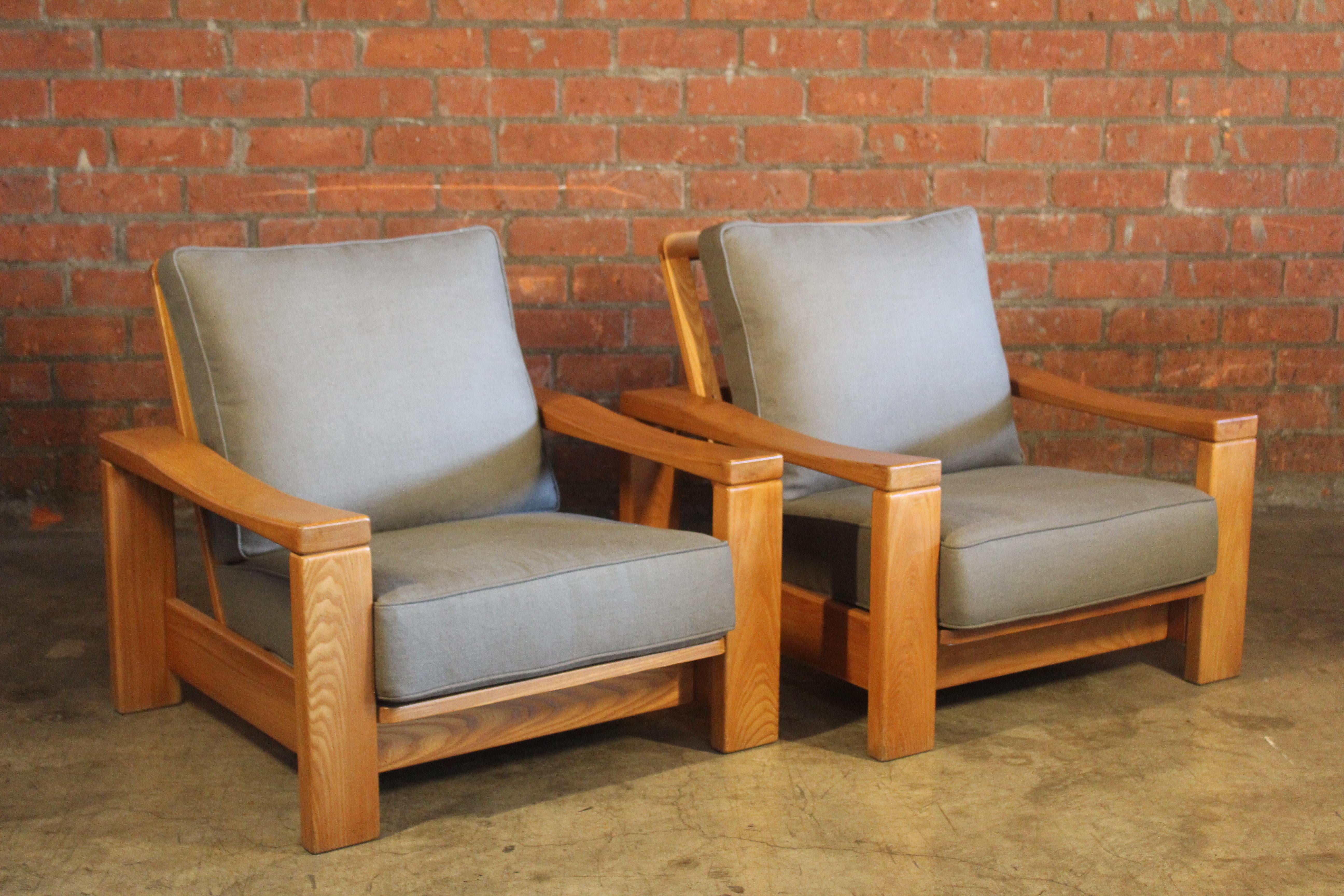 Pair of solid elm lounge chairs from France, 1970s. Newly upholstered in an olive green Belgian linen. The pair are in good condition with original finish to the elm wood frames. They show very minimal signs of wear.