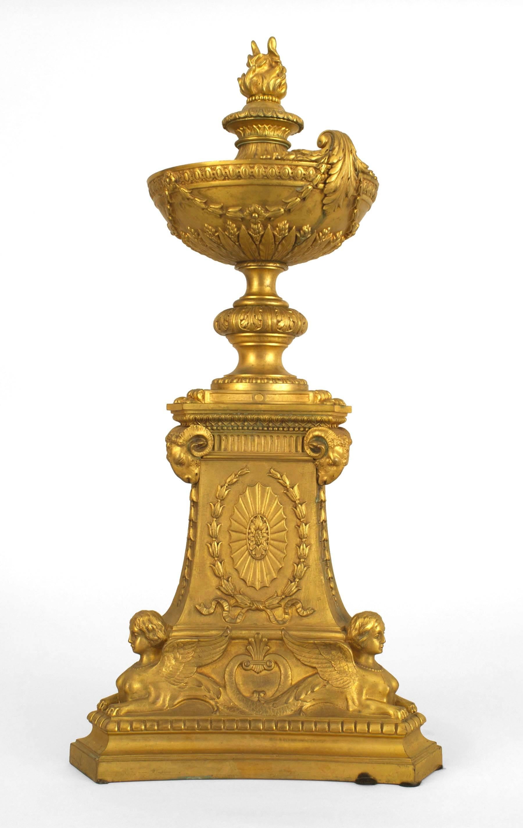 Zwei vergoldete Bronze-Urnen aus dem französischen Empire (19. Jh.) mit dreieckigen Sockeln und sphinxförmigen Widderköpfen. (PREIS ALS PAAR)
