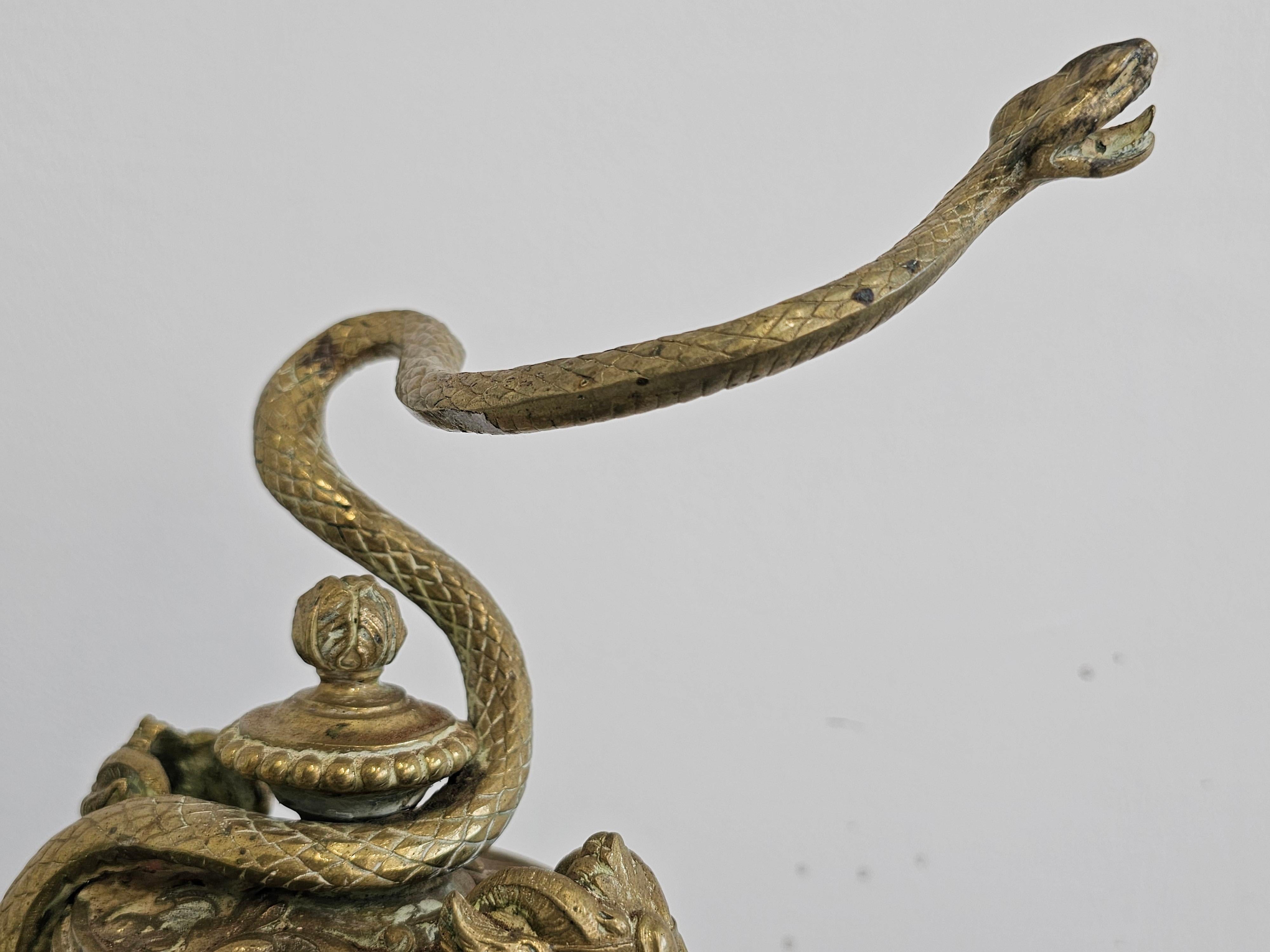 Brass Pair of French Empire Andirons done in gilt brass, featuring snakes and ram head For Sale