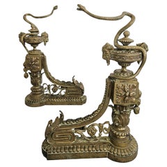 Pair of French Empire Andirons done in gilt brass, featuring snakes and ram head