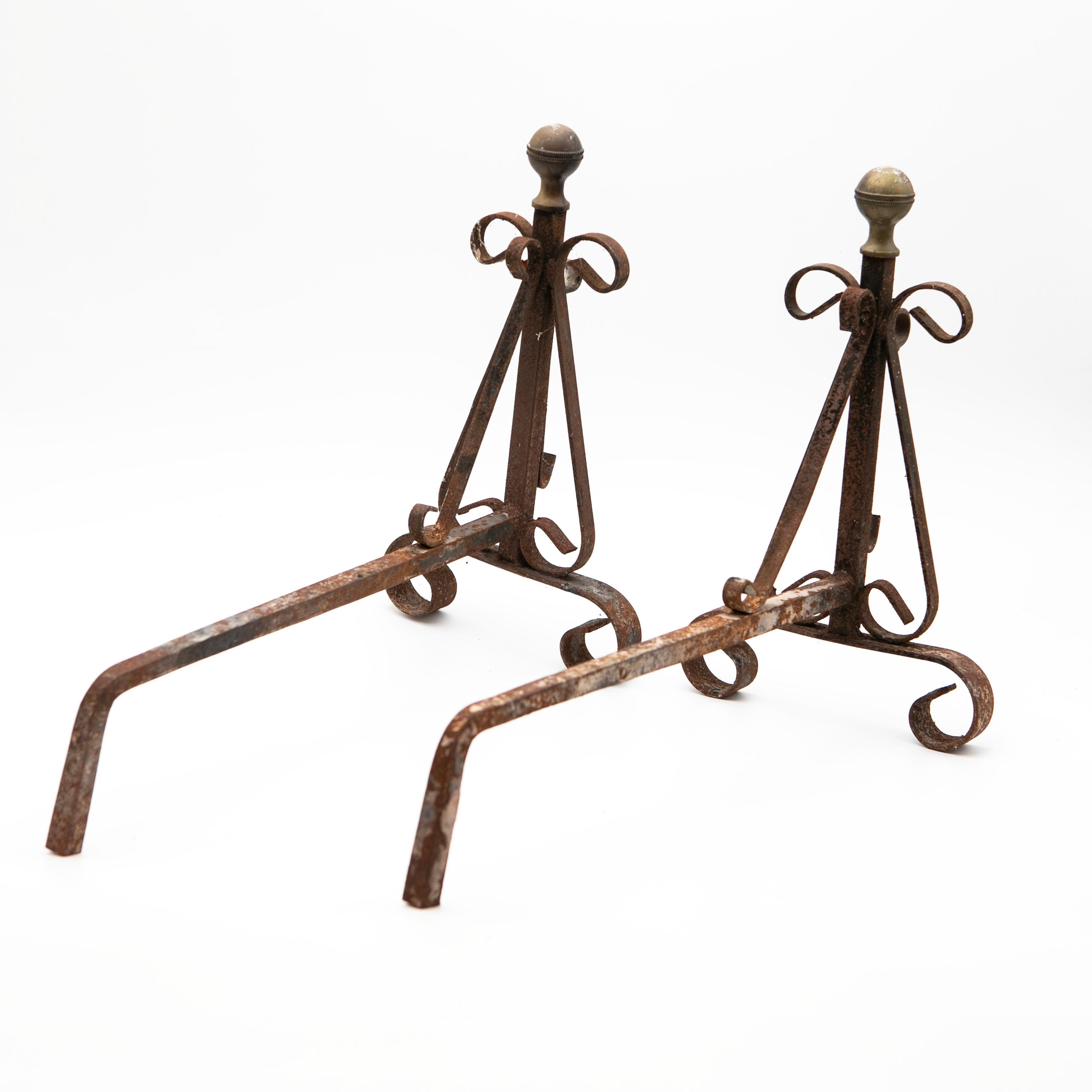 Un'affascinante coppia di androni francesi Eleg realizzati in ferro battuto, con eleganti terminali in ottone sui piani anteriori.
Questi supporti per caminetti sono presentati nella loro condizione originale e intatta, con una patina naturale che