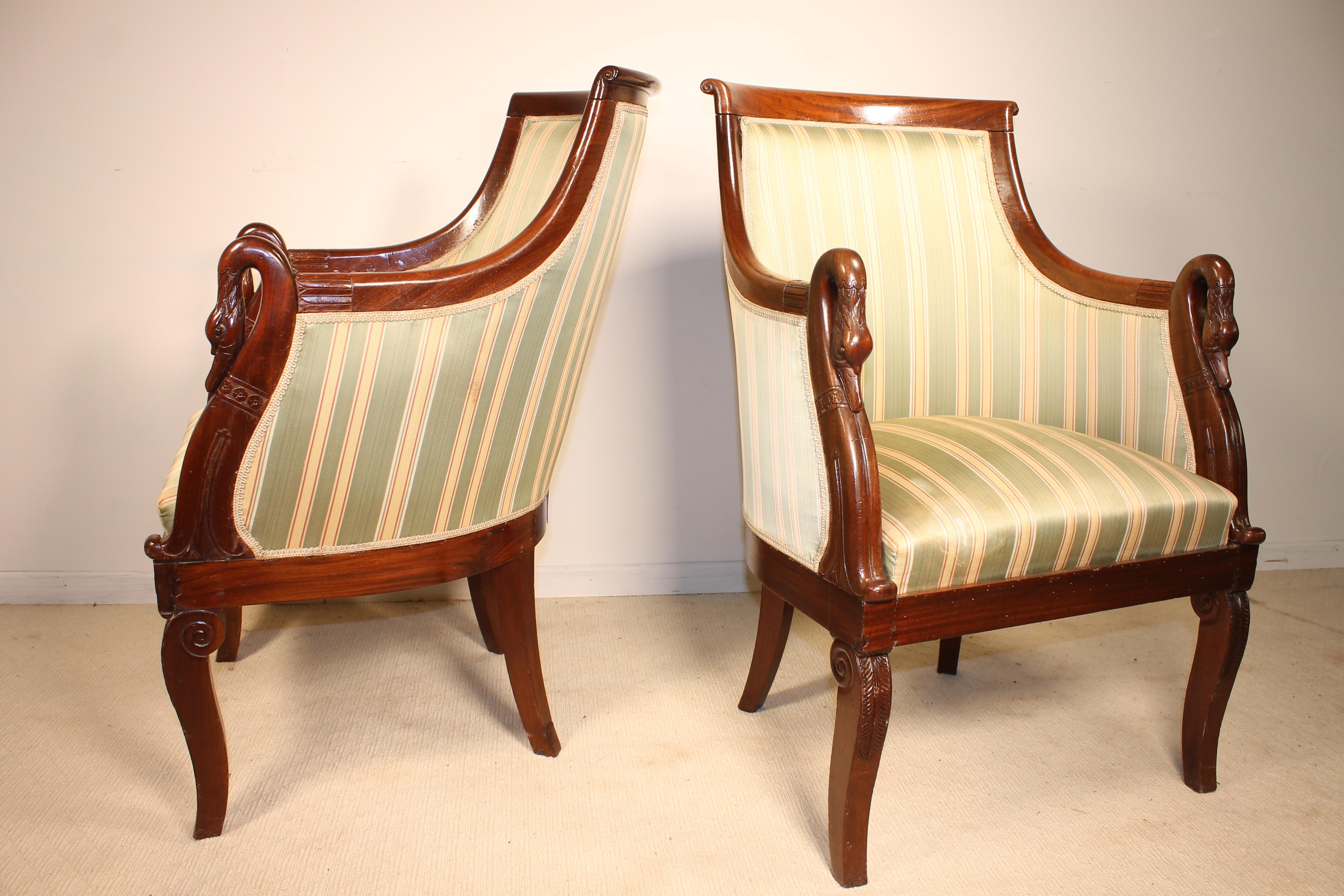 Very beautiful pair of French Empire armchairs in mahogany. 

This typical armchair called in French 'col de cygne' literally translated Swans neck have a very Fine swan carving. 

Those chairs have a typical Empire silk fabric. 

Very