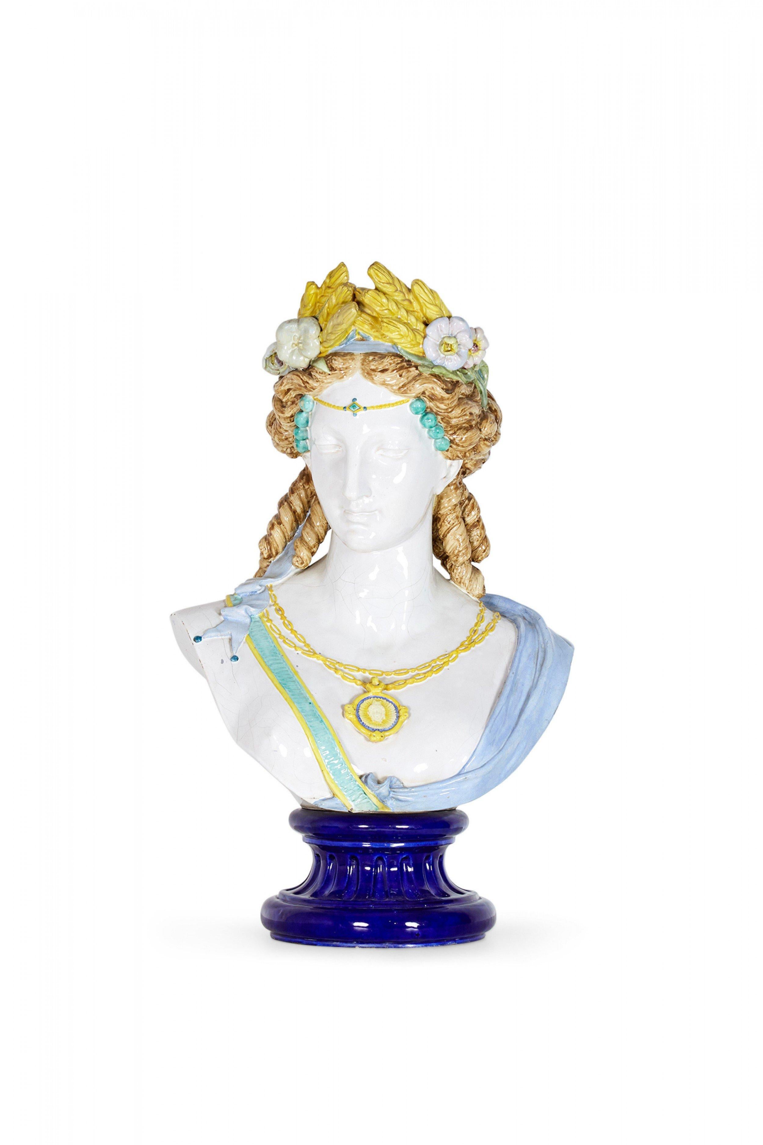 Pair of French 2nd Empire (circa 1865) large faience busts in polychrome pottery depicting female figures adorned in laurels of wheat and grapes on separate round fluted pedestal bases (signed AUGUSTE JEAN, FRANCE, 1829-1896).