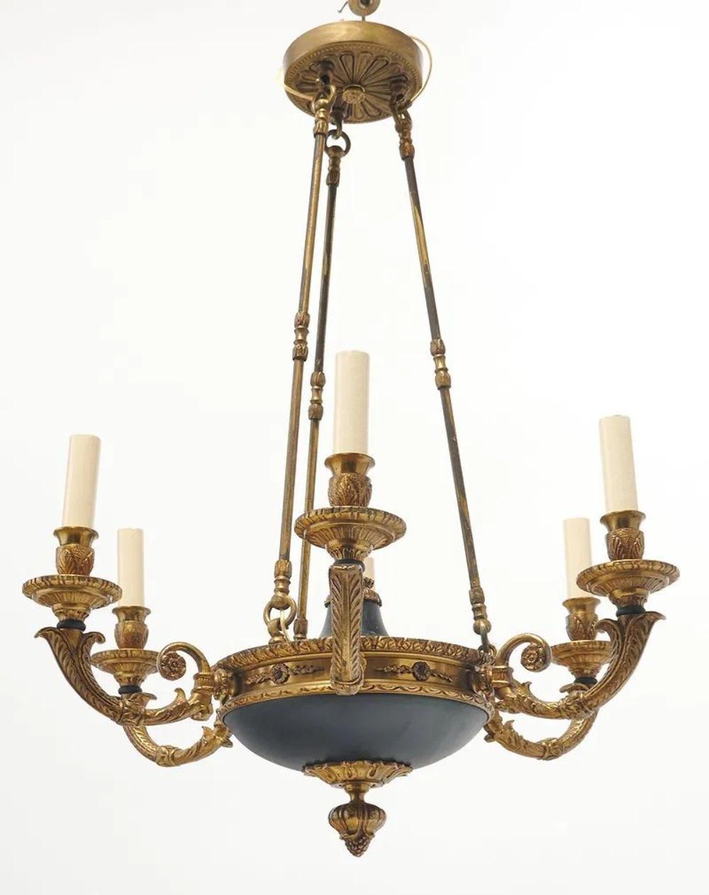 Bei dem Produkt handelt es sich um ein Paar sechsarmige Kronleuchter im französischen Empire-Stil aus schwarzem Zinn und Bronze.  Diese eleganten und zeitlosen Kronleuchter sind eine wunderbare Ergänzung für jedes Haus. Mit ihren filigranen Details