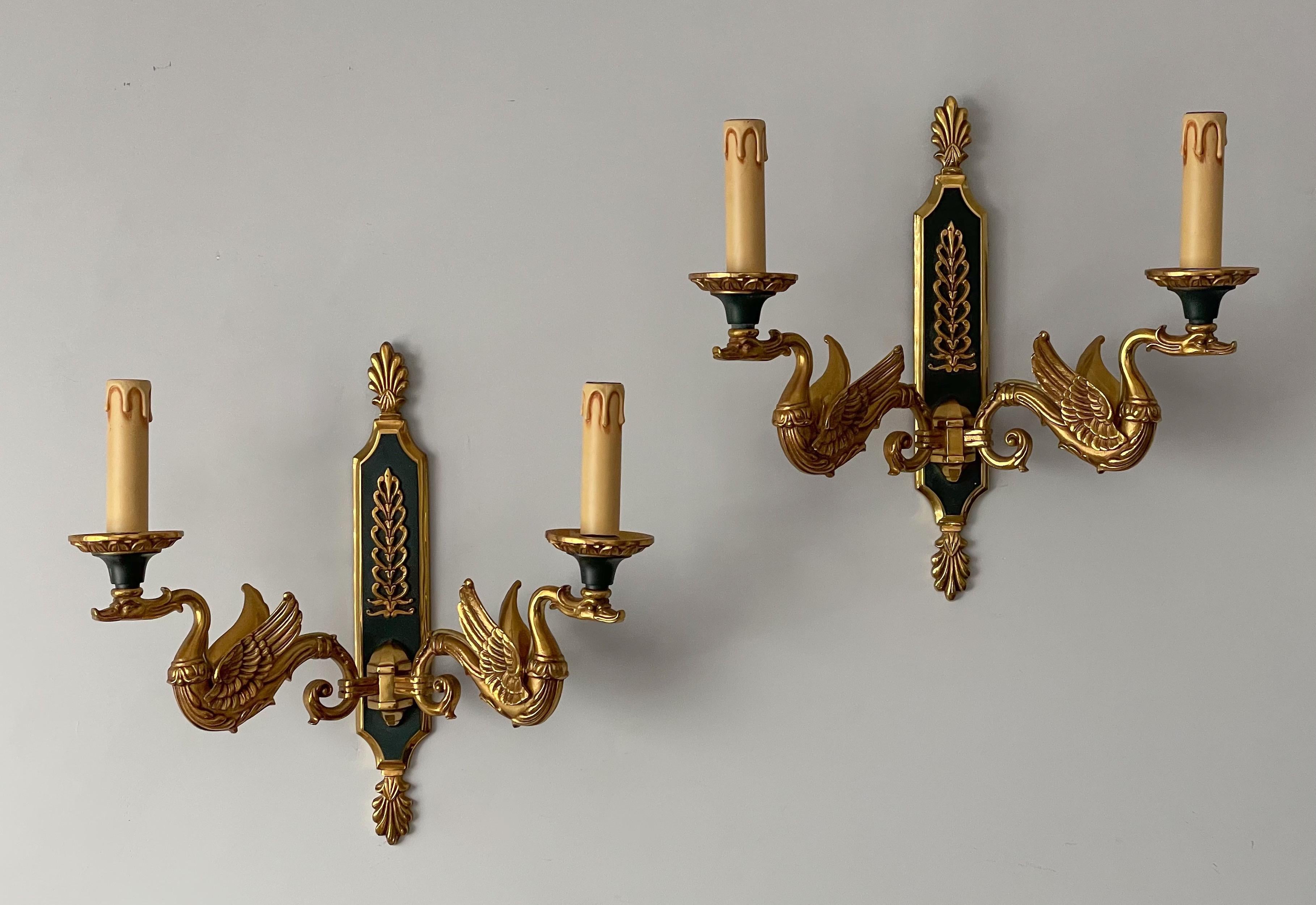 Beautiful, pair of French Empire-style sconces by Maison Lucien Gau, Paris.

The sconces are constructed of solid bronze with a doré and imperial green finish. Finely cast ormolu decorations include a swan under each of the candelabra lights. 

The