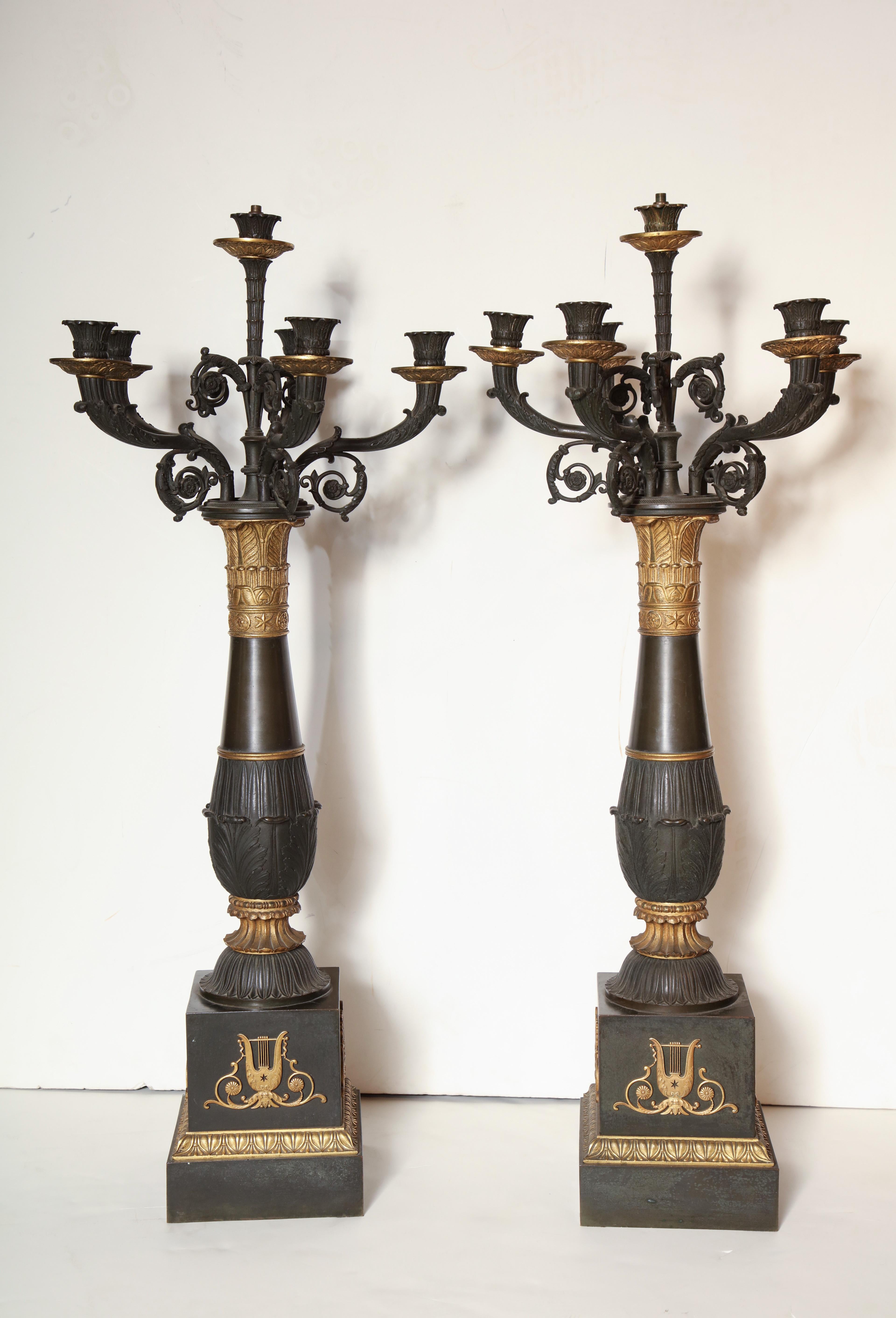 A fine and large pair of French Empire column-form candelabra with patinated and gilt bronze decoration to the column and square plinth base.