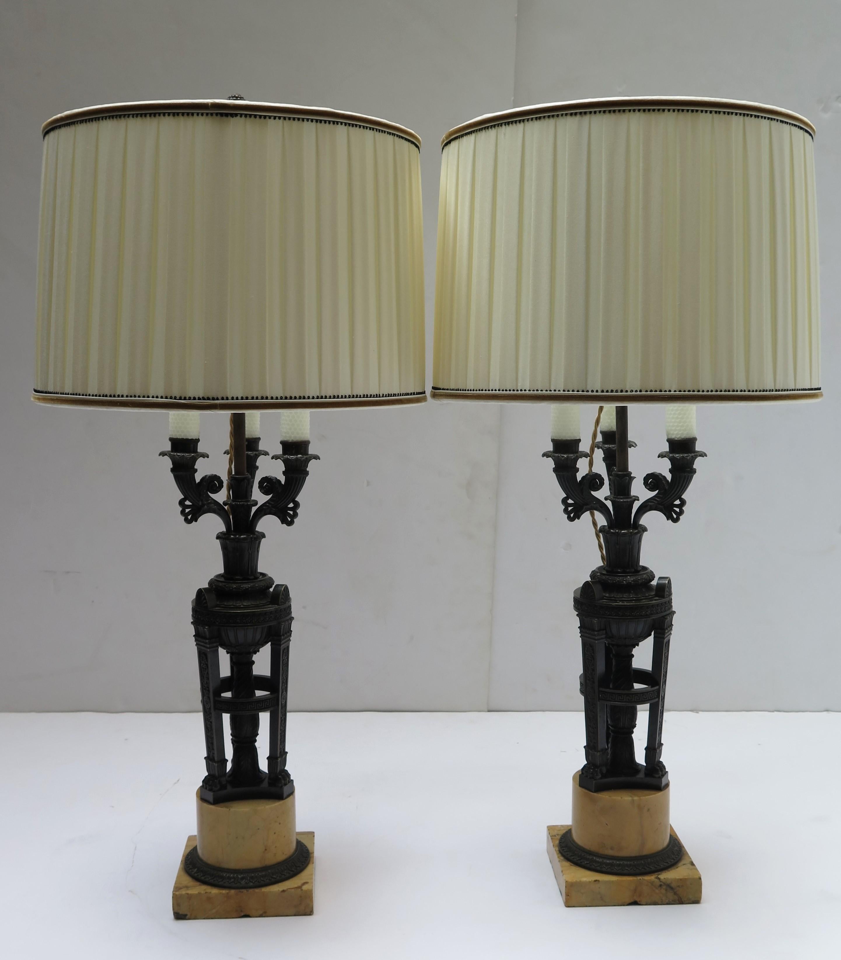 A pair of French Empire patinated bronze and sienna marble 3- light candelabra in the manner of Pierre- Philippe Thomire now as lamps with custom box pleated shades and trim.

Diameter of the shades: 17.25