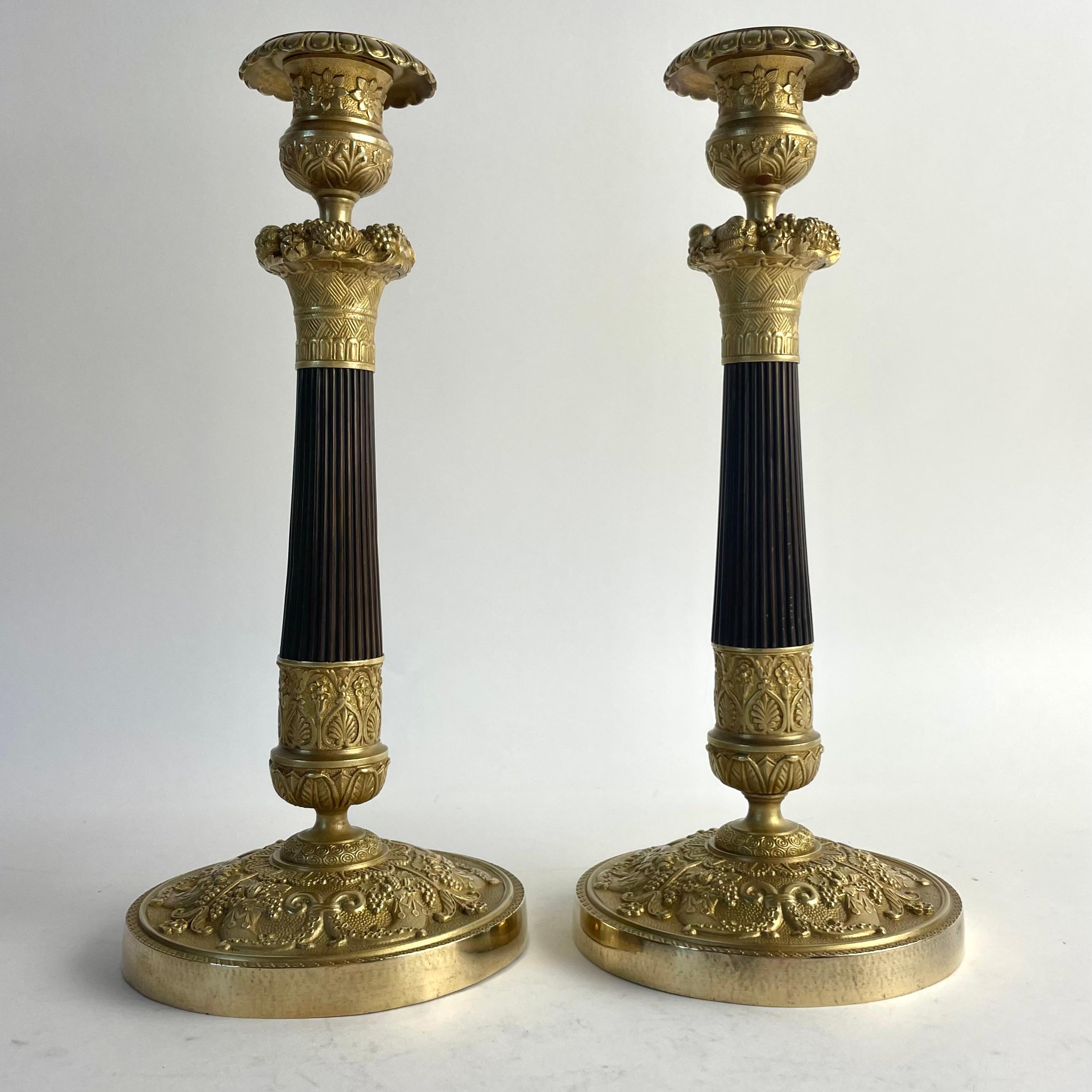 
Pair of French Empire Candlesticks in Gilt and Patinated Bronze, circa 1820

Elegant and richly detailed pair of French Empire candlesticks from the 1820s. Crafted in gilt and dark patinated bronze, these candlesticks feature classic Empire motifs
