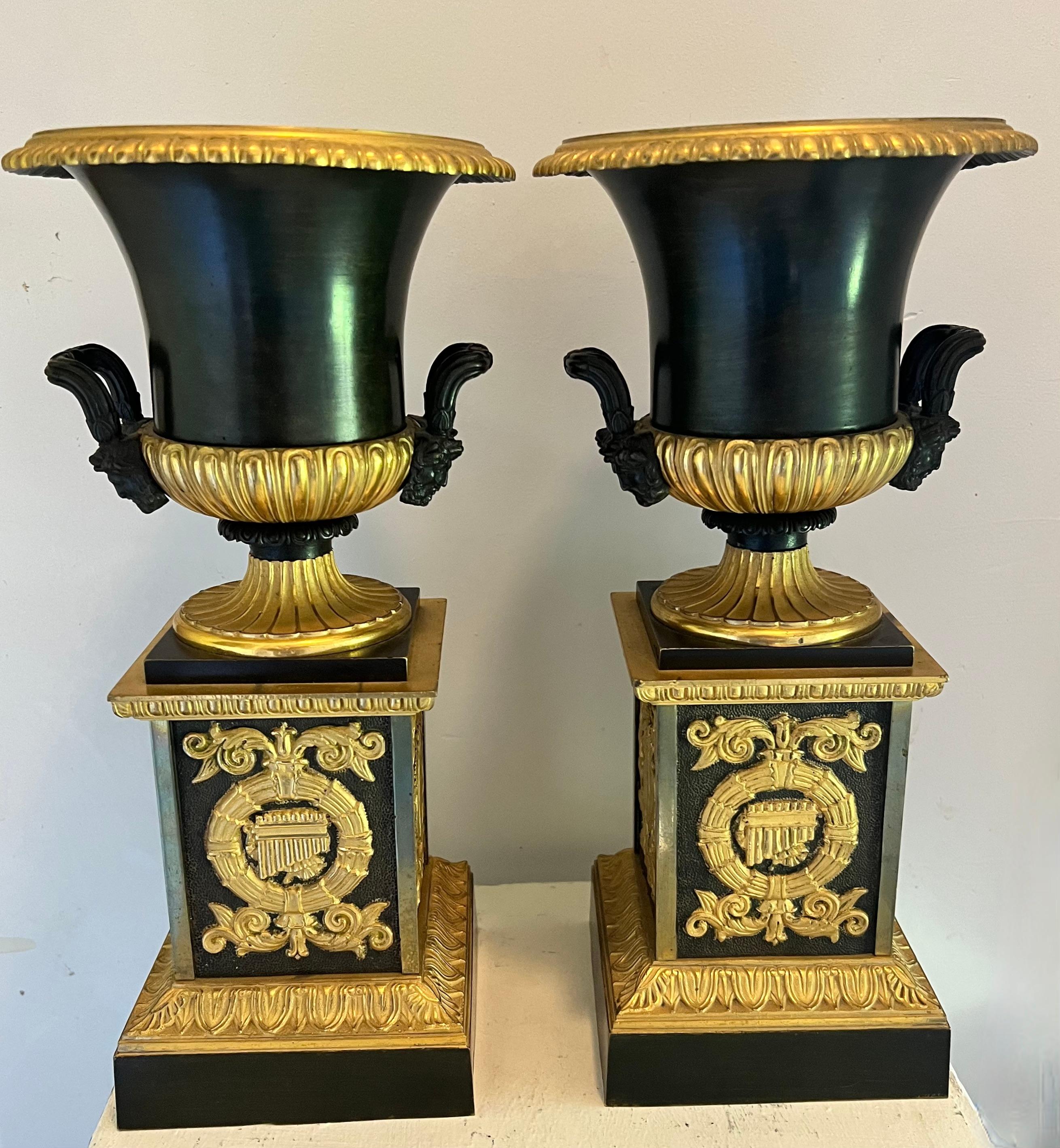A beautiful pair of quality bronze Dore Urns on Pedestals.  The pair are in wonderful vintage condition.  one small bend to the lip or edge of one - not greatly noticeable or offense... the two are a great pair - we prefer them stand alone and not