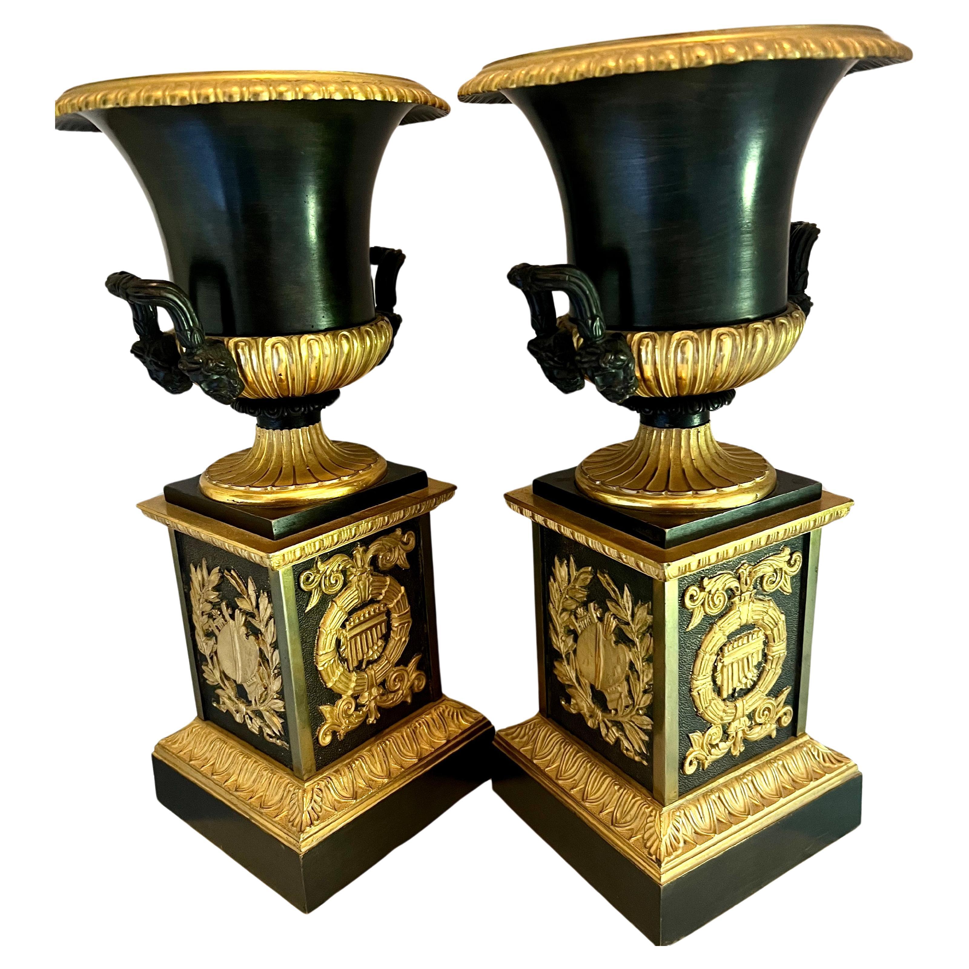 Paire d'urnes Empire françaises en bronze doré sur piédestaux