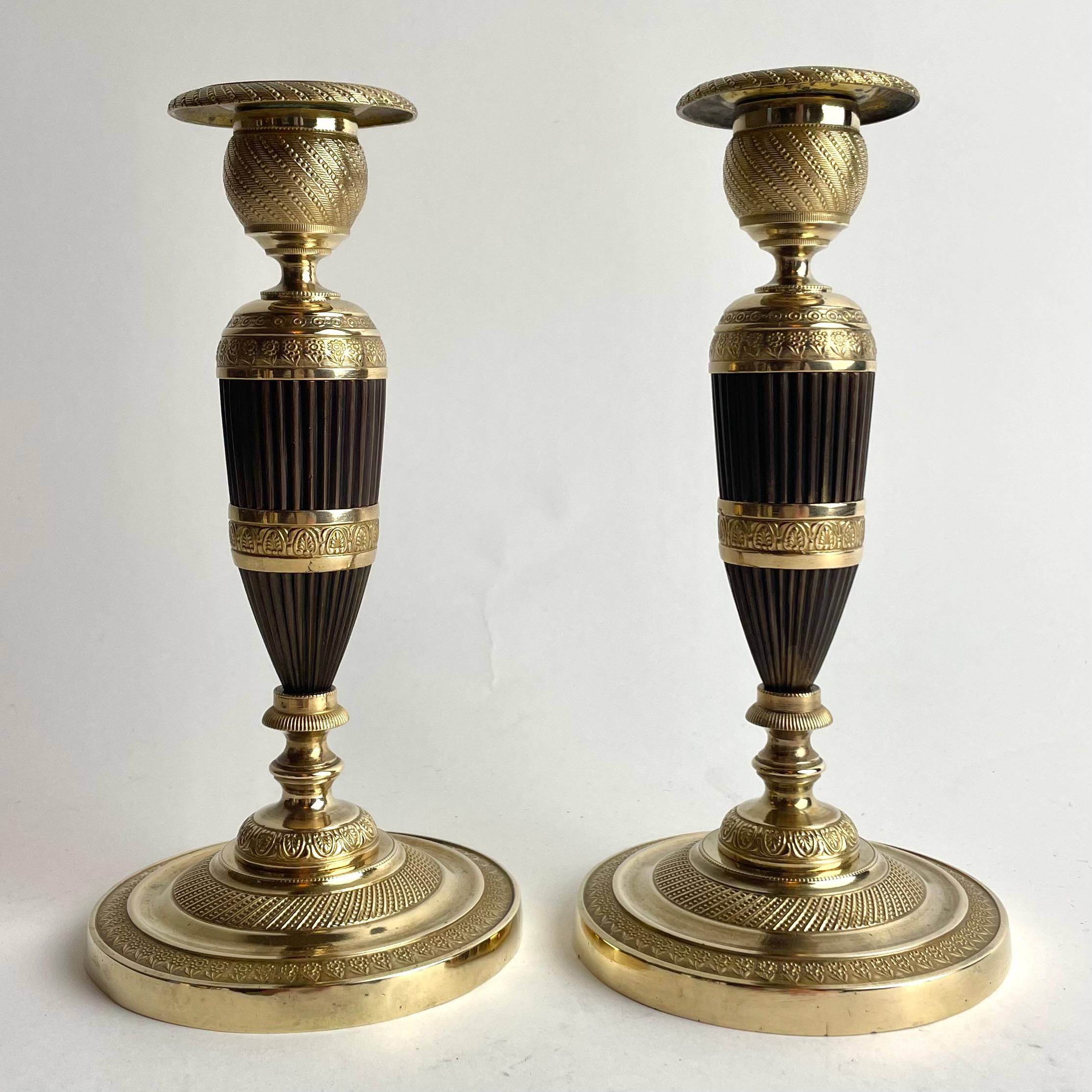Pair of French Empire Gilt and Patinated Bronze Candlesticks, 1820s

An elegant and unusual pair of French Empire candlesticks, finely executed in gilt and dark-patinated bronze. Each piece stands on a circular, stepped base richly chased with