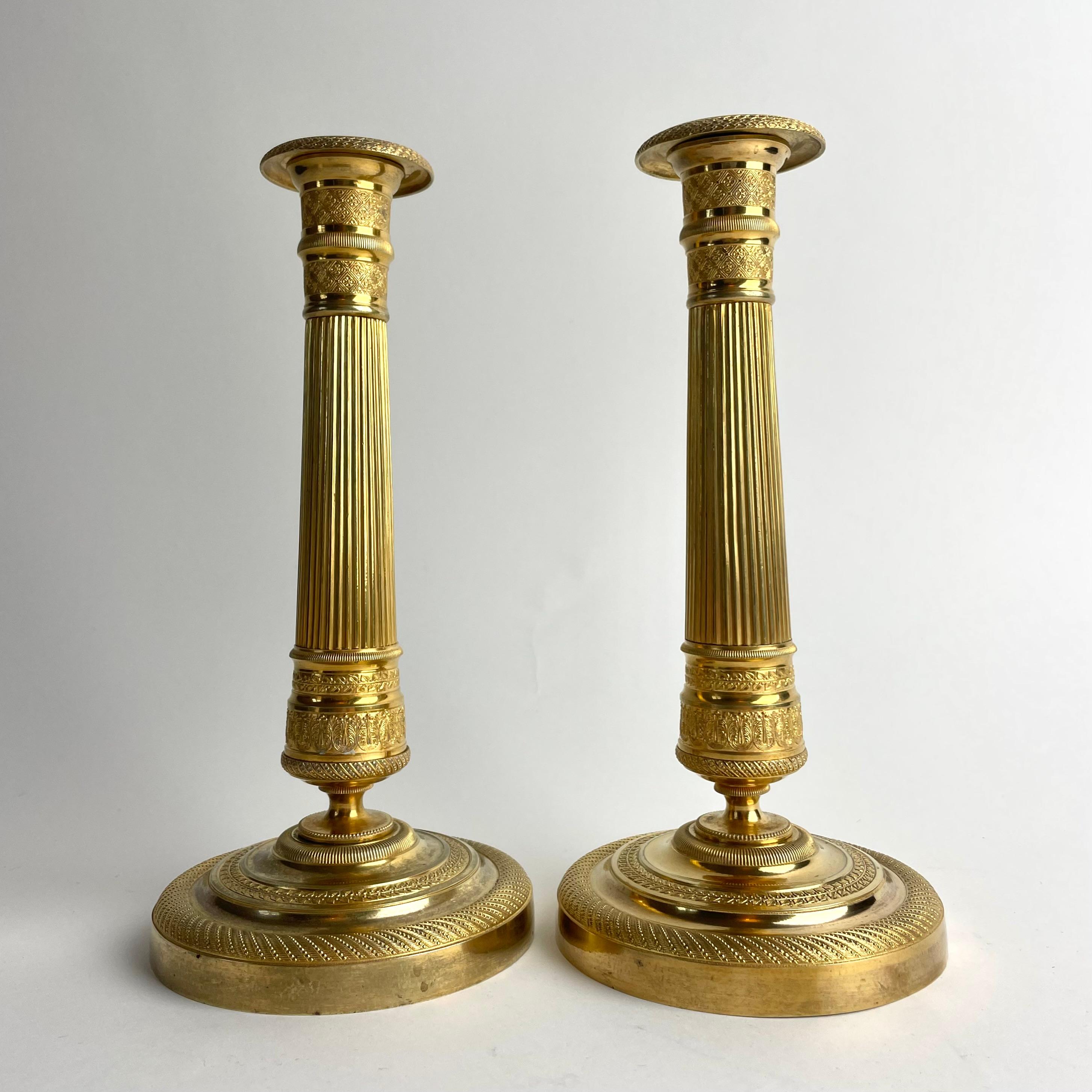
Coppia di candelieri francesi in bronzo dorato Impero, anni '20 del XIX secolo

Una raffinata coppia di candelieri Impero in bronzo dorato, realizzati in Francia intorno agli anni '20 del XIX secolo. Il design presenta gli eleganti fusti scanalati