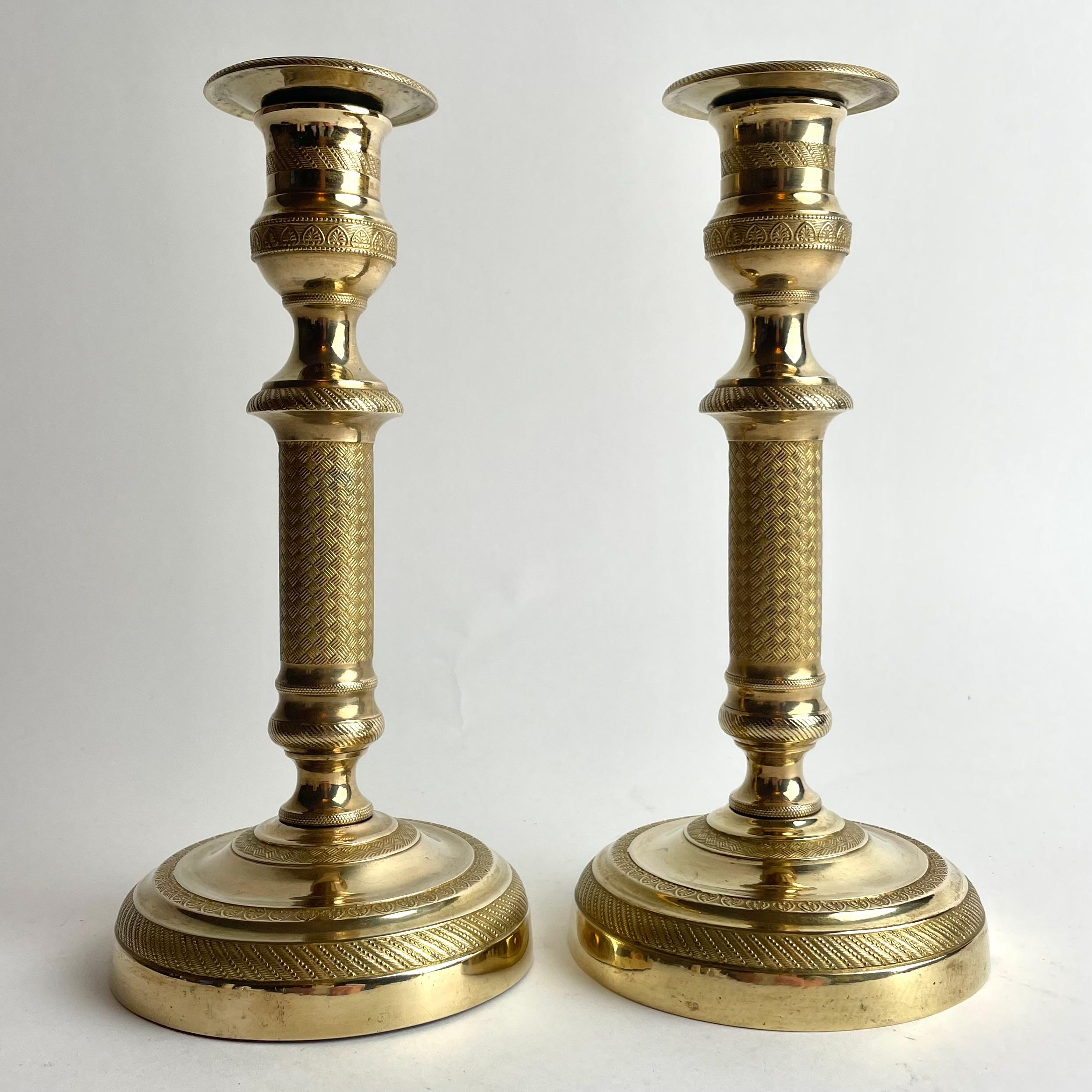 Pair of French Empire Gilt Bronze Candlesticks, 1820s

A powerful and elegant pair of French Empire candlesticks, masterfully cast in gilt bronze with fine neoclassical detailing. The circular, stepped bases are richly adorned with alternating
