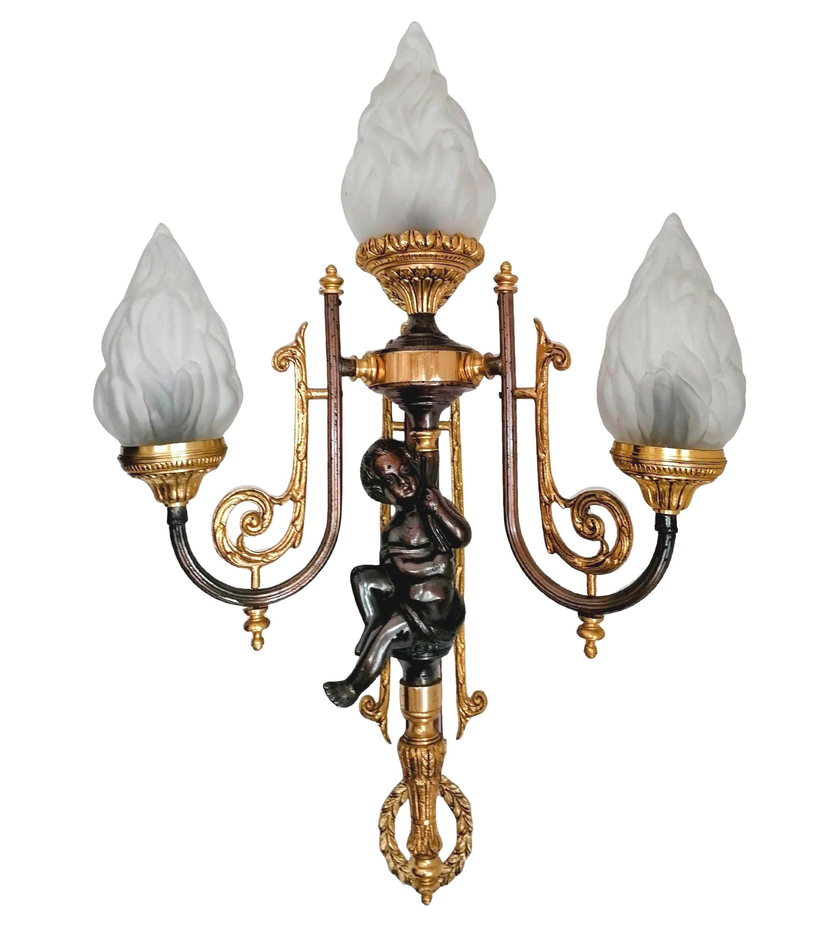 Impresionante y pesada pareja de apliques Imperio francés de estilo neoclásico. Cada candelabro presenta un querubín de bronce patinado, finamente fundido, sentado graciosamente en la columna central, flanqueado por dos brazos de bronce dorado con