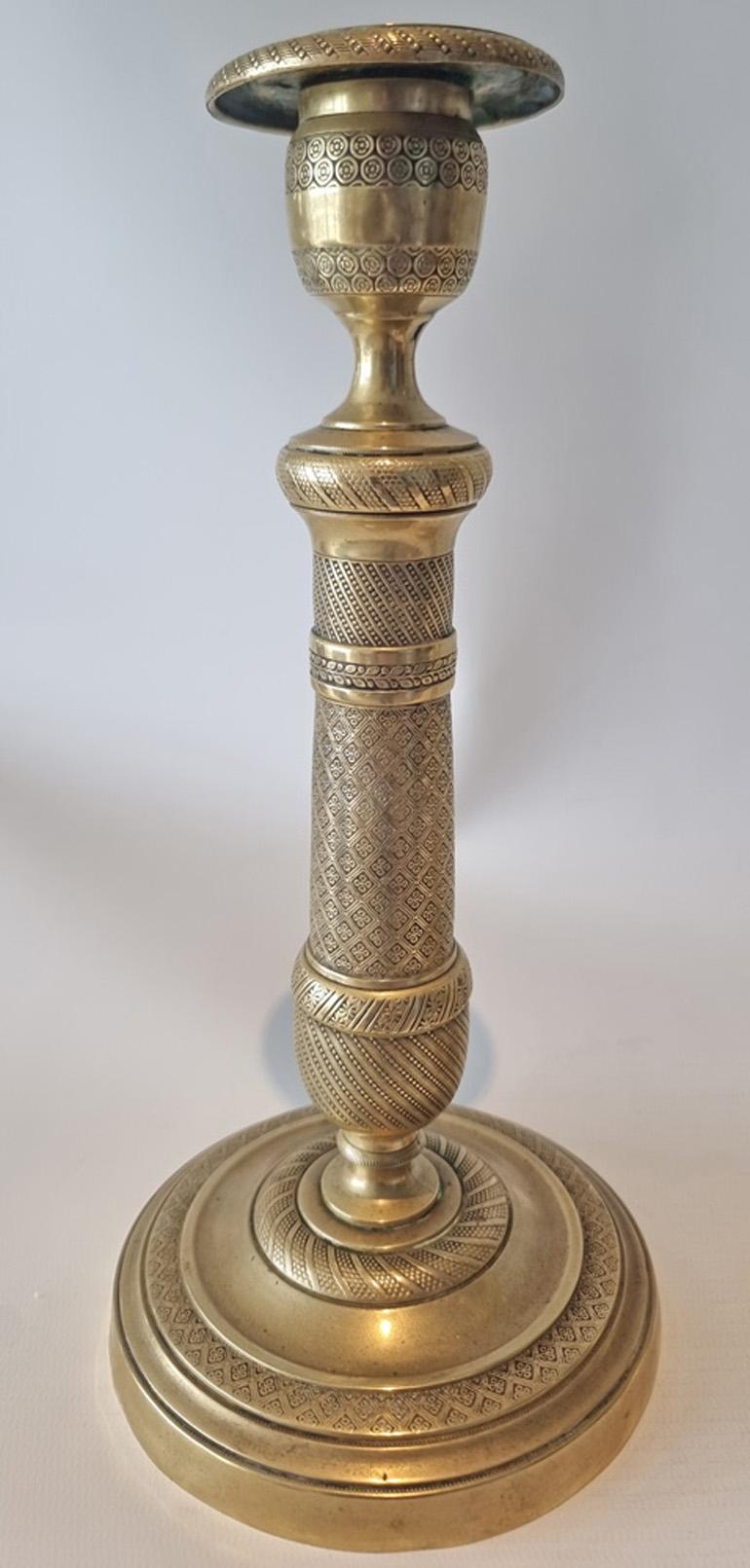 French Empire ormolu candlesticks of outstanding quality. Set on a circular base with unusually a decorated band around the top outside edge of the base comprising dots within diamonds. Within this is a gadrooned moulding leading to the domed foot