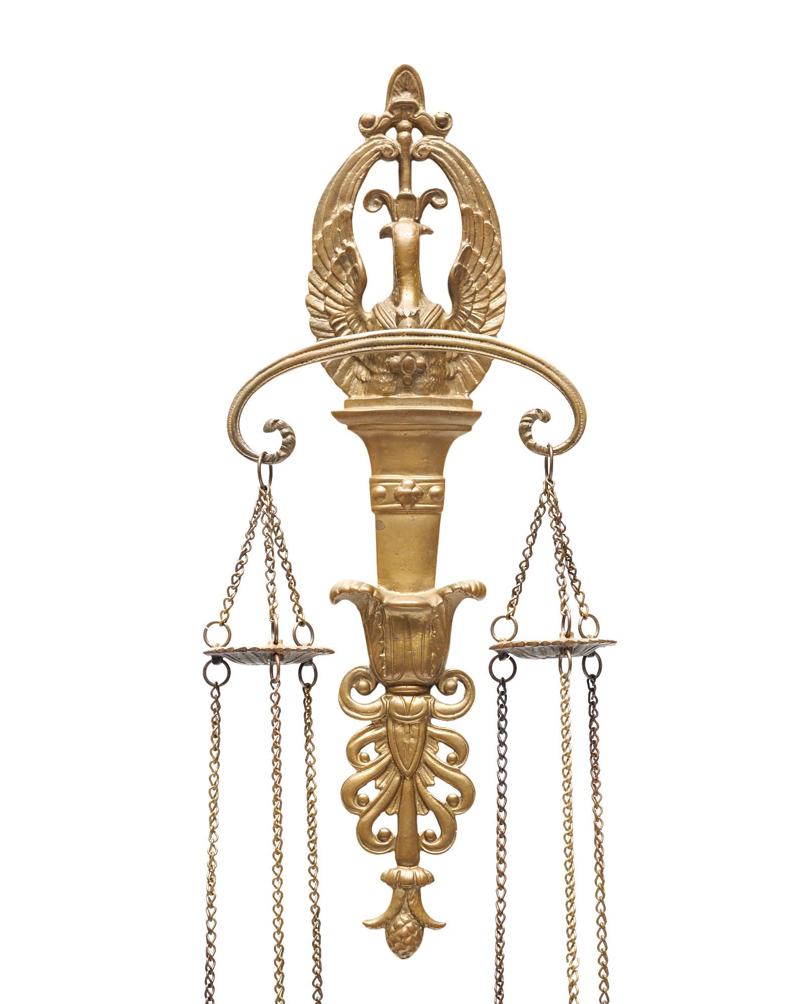 Candle holder sconces from France from the Empire period. This finely cast pair of sconces features a solid brass structure with a swan holding two chained candle sconces. In the French Empire period the swan was the symbol of Empress Joséphine.