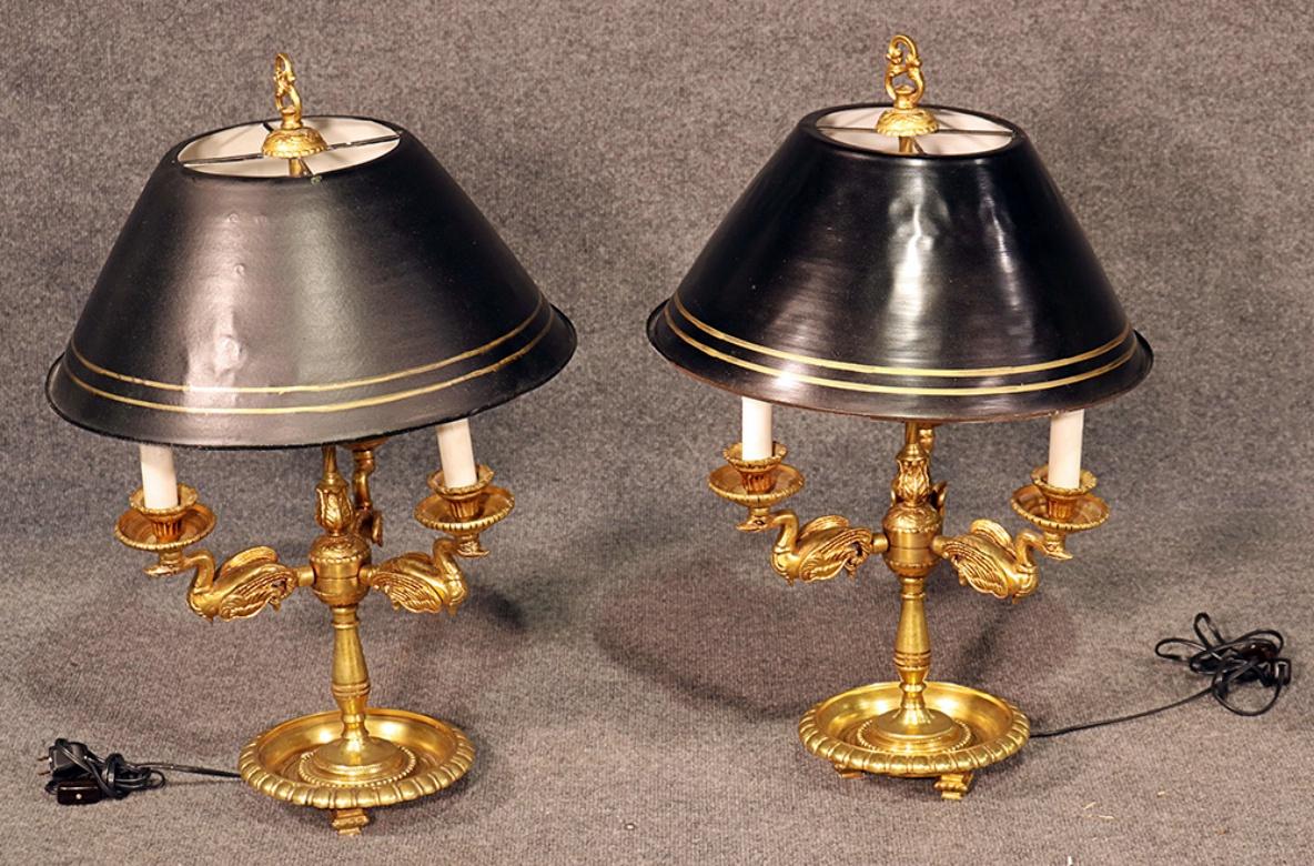This is a heavy and substantial pair of French Empire style brass swan bouillotte table lamps with tole shades.