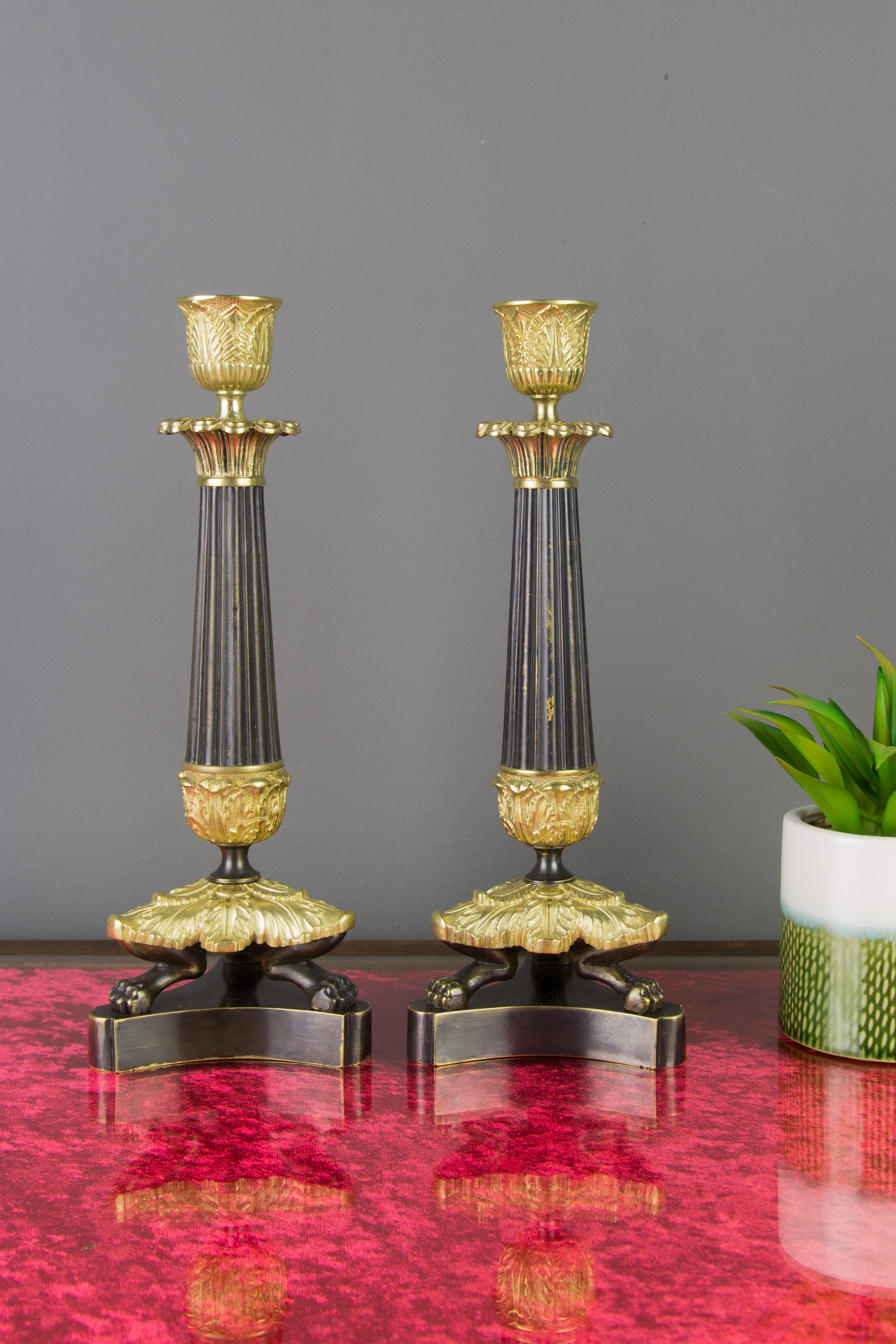 Paar französische Kerzenständer aus Bronze und Messing im Empire-Stil auf dreibeinigem Sockel (Patiniert) im Angebot