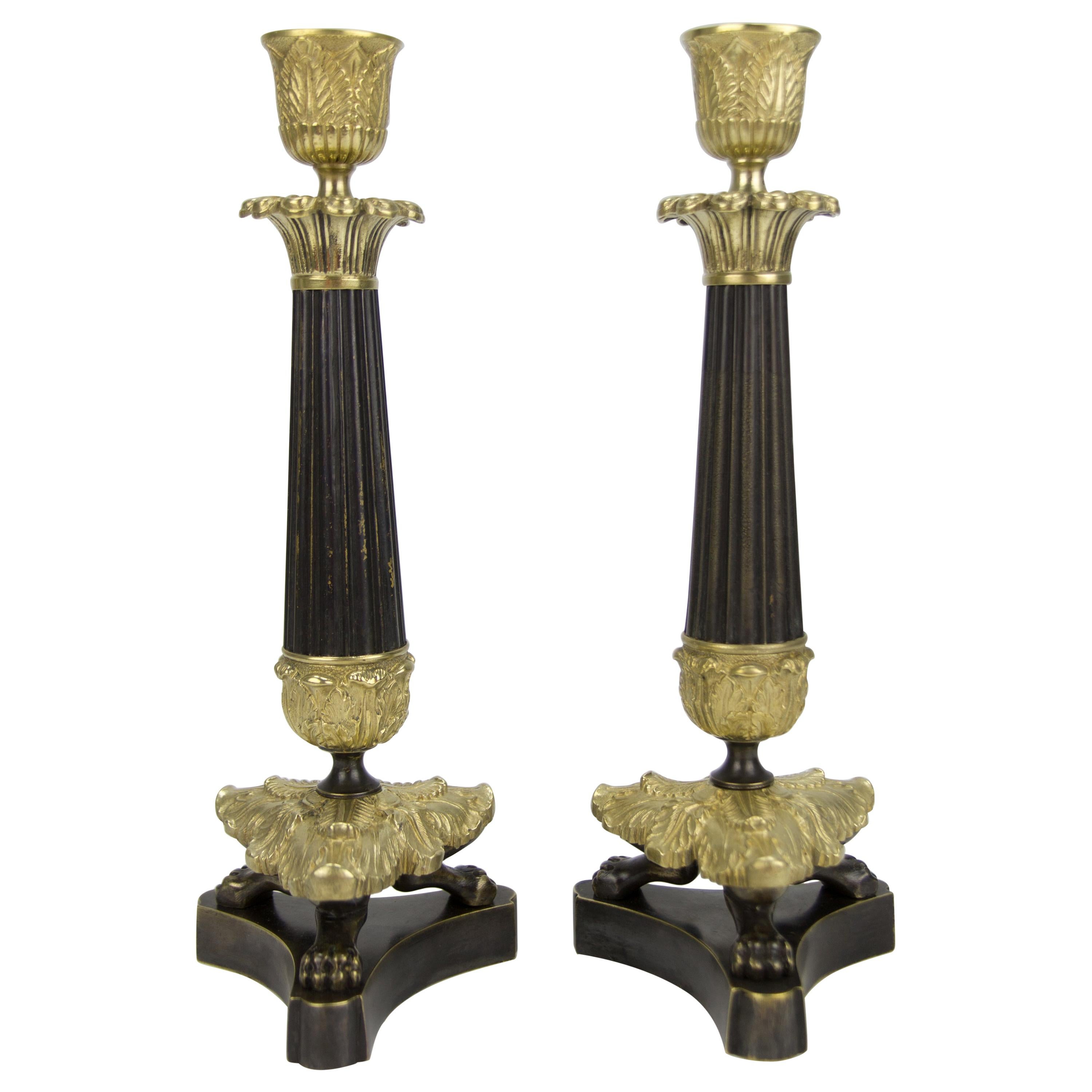 Paar französische Kerzenständer aus Bronze und Messing im Empire-Stil auf dreibeinigem Sockel