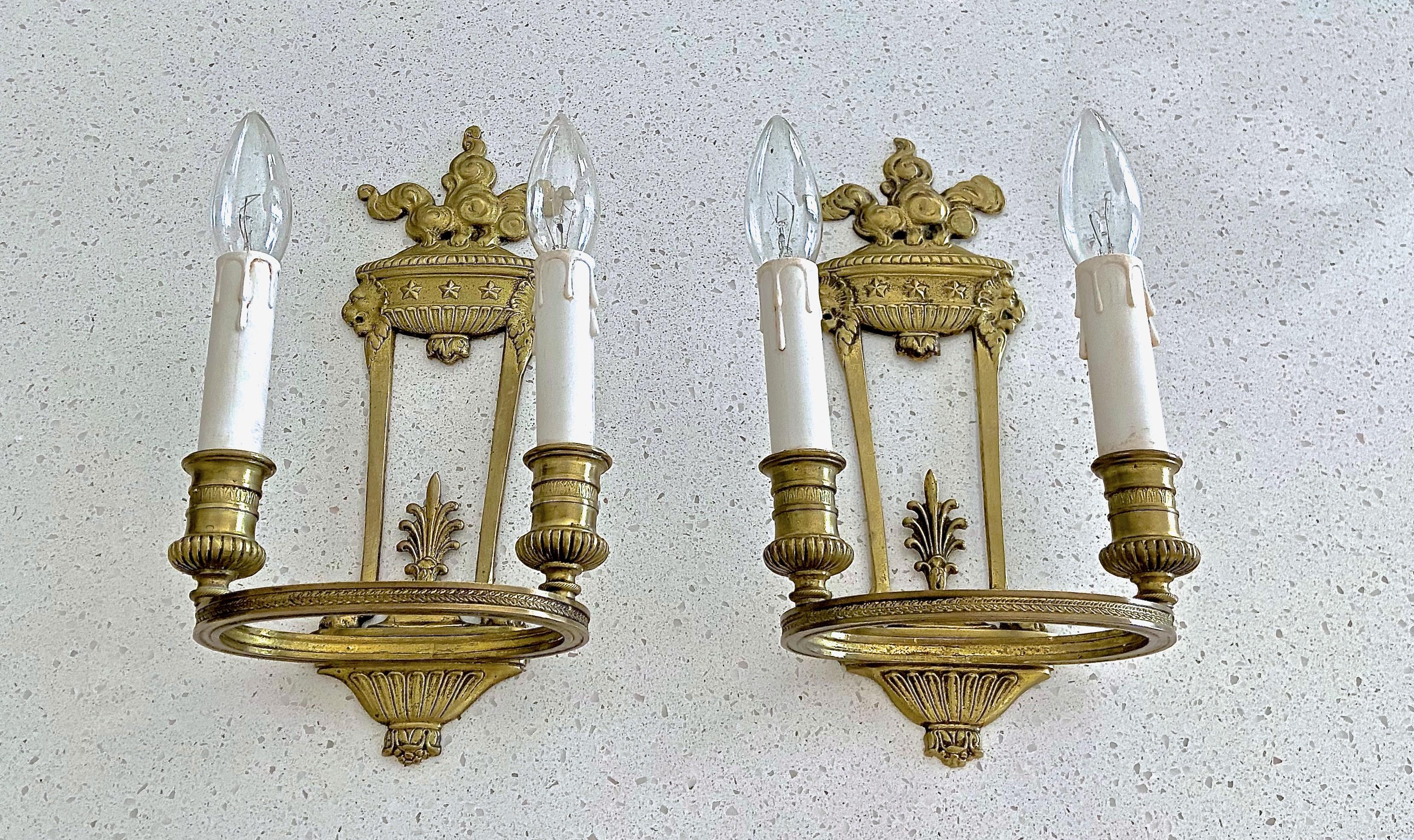 Pair of nicely detailed French 1920s Empire style two light wall sconces with lion and star motif. The sconce frame attaches to wall using a hook (see close up showing where the hook attaches). If needed will provide a 5