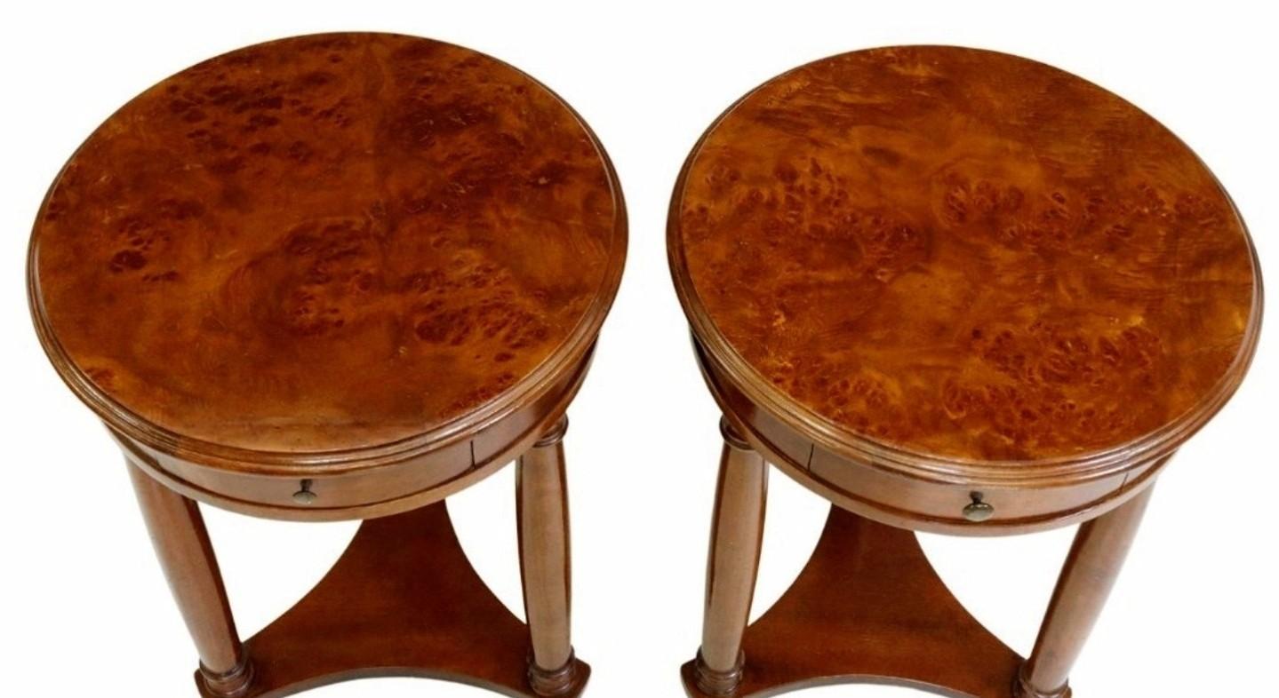 A pair of mid-century French Empire style side tables, having a round burlwood tabletop, over a single drawer, rising on columnar supports, shaped stretcher, ending in turned feet. 

Dimensions: (approx)
Each: 27.75