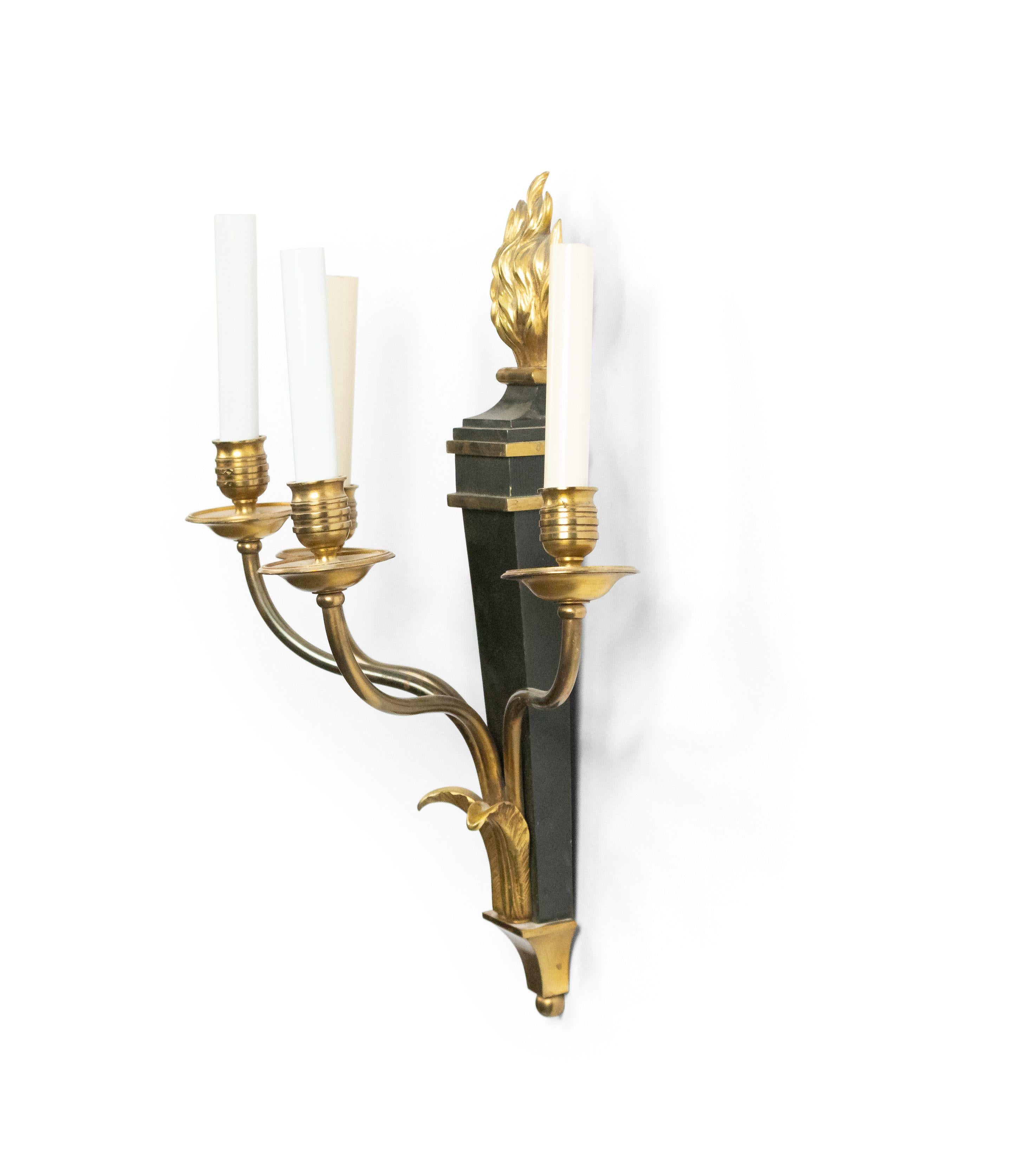 Pair of French Empire style ebonized and gilt four-arm wall sconces with flame top (20th century).
 
