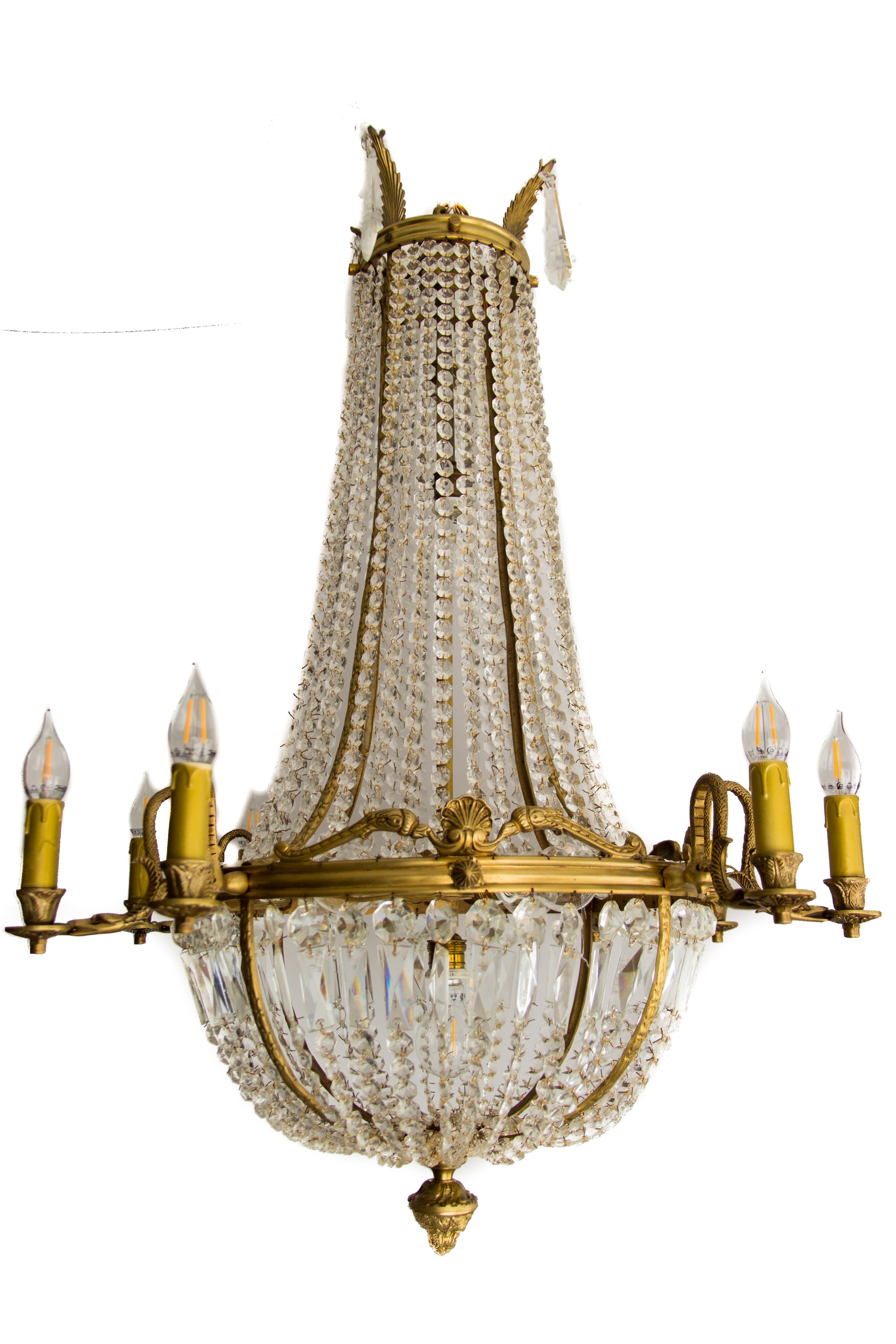 Each impressive fifteen-lights basket chandelier has ten bronze arms shaped as stylized swan heads holding perimeter lights with E14 sockets. Five interior tiered lights with E27 sockets. The crown is decorated with bronze plumes and crystal