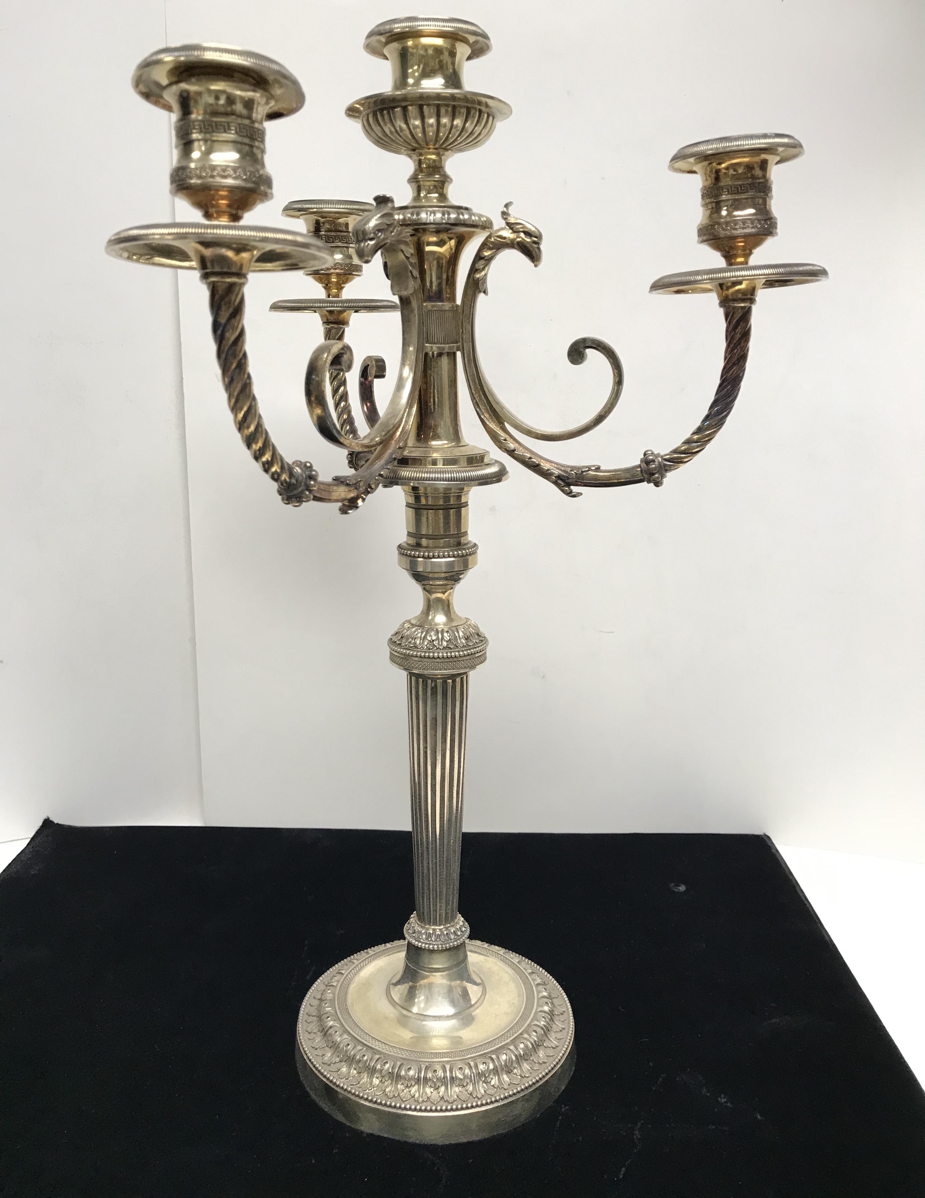 Pair of gilt-metal four-light candelabras, probably French, c. 1900, designed in the Empire style, the base with acanthus borders, the body having reeded, beaded, fluted decorations and fluted stems, the torsed arms ending in gryphon heads, with