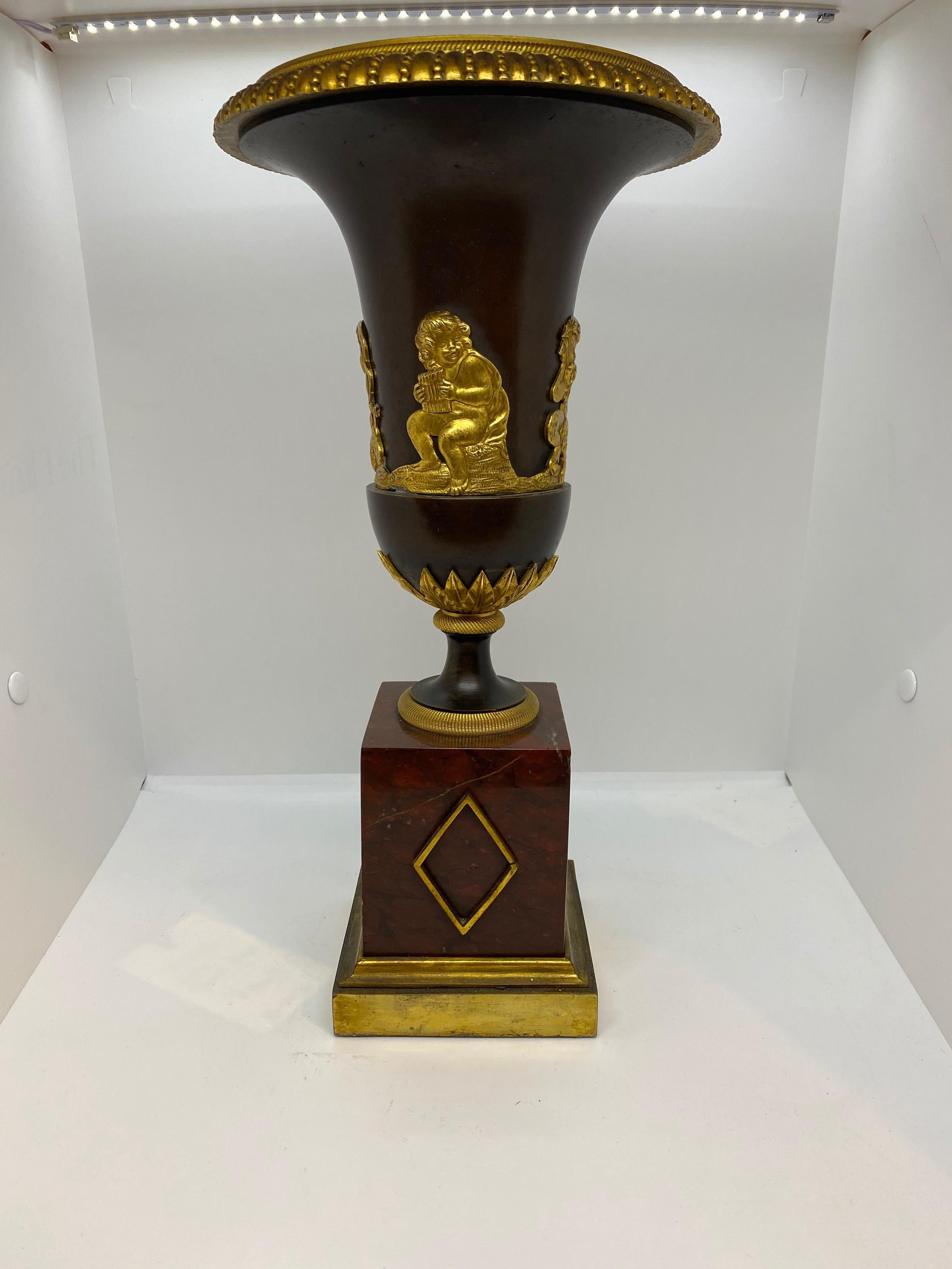 Pair of French Empire bronze vase on rouge marble plinths with gilt bronze appliqués. Now mounted as lamps.