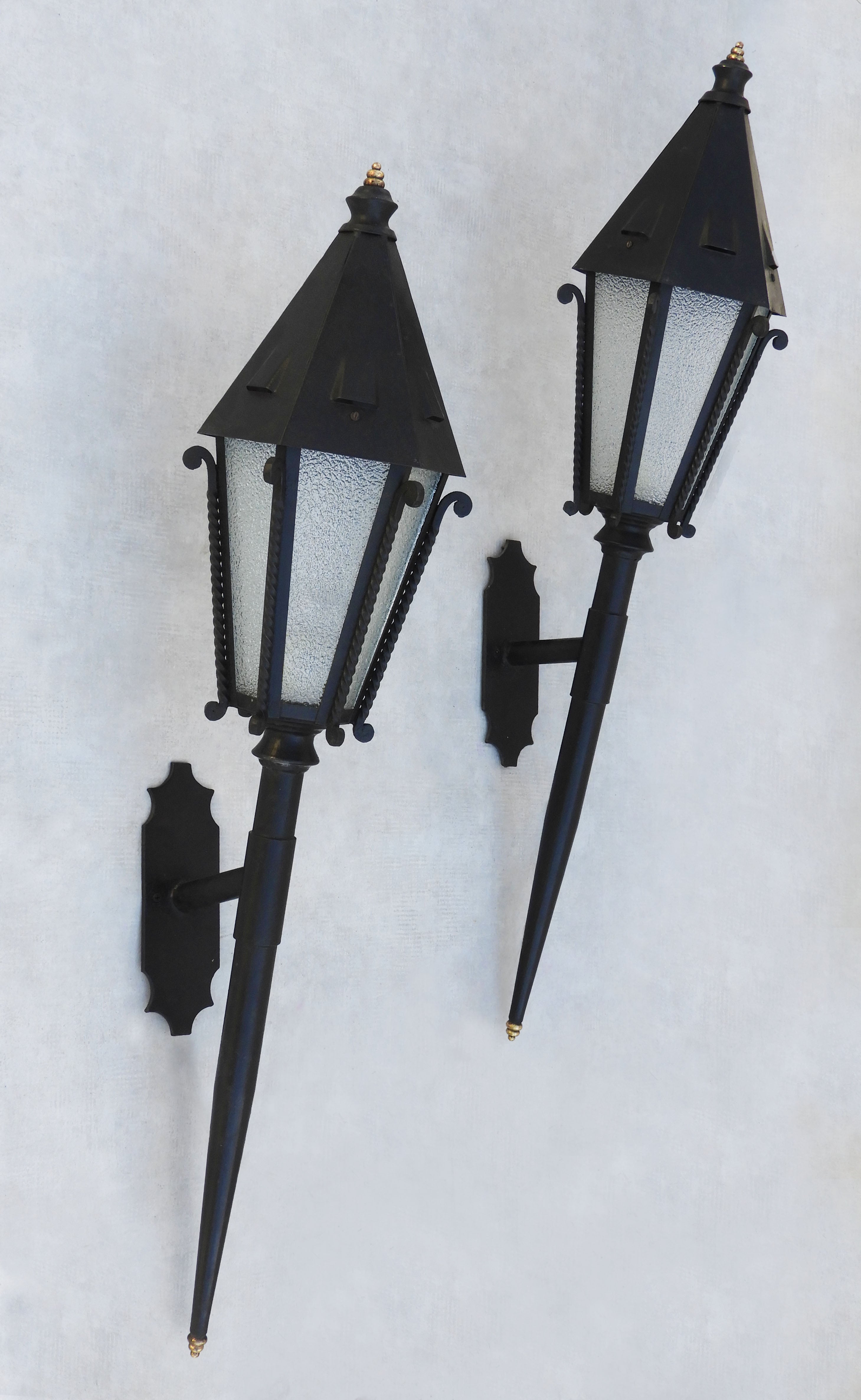 A great pair of mid century French torchère lanterns circa 1950. Six sided 'roof topped' lanterns with barley twist wrough itron detailing, givré frosted glass on tall bracketed torchère poles.  In very good vintage condition with nice aged patina. 