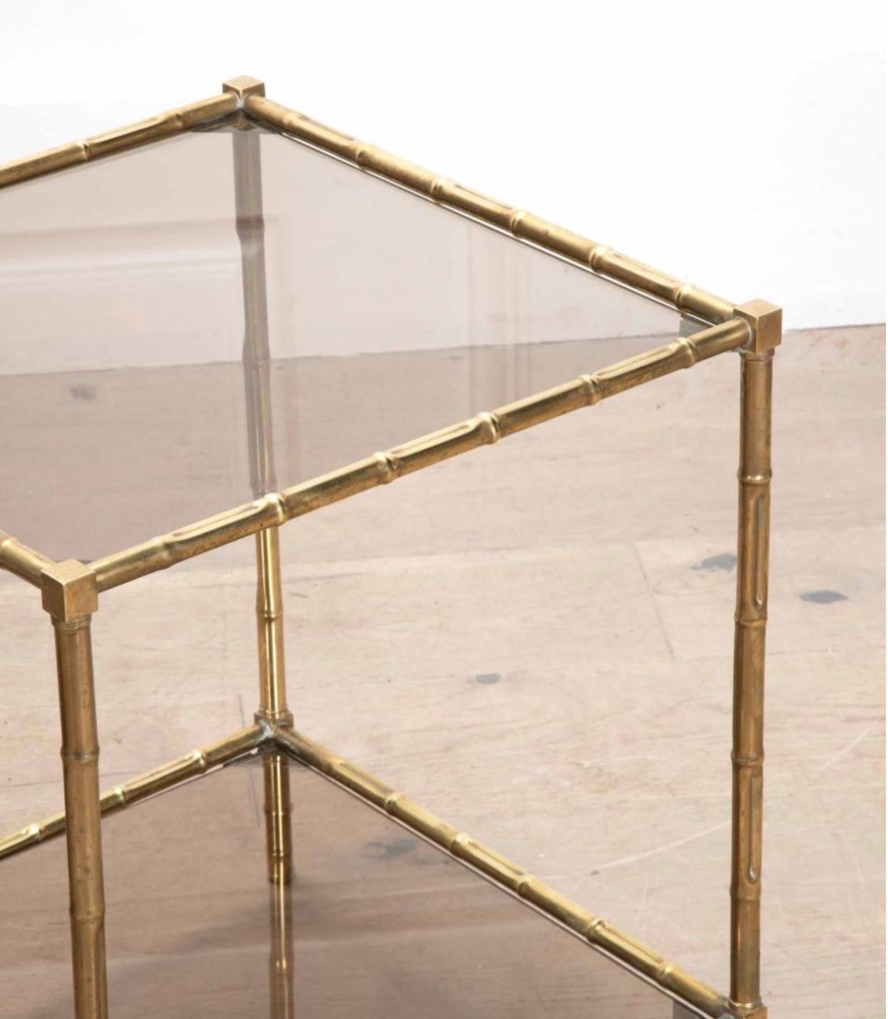 Paire de tables d'appoint en faux bambou et laiton avec plateaux en verre fumé et étagères sous le plateau. 

Construction solide et robuste. Vers les années 1950.