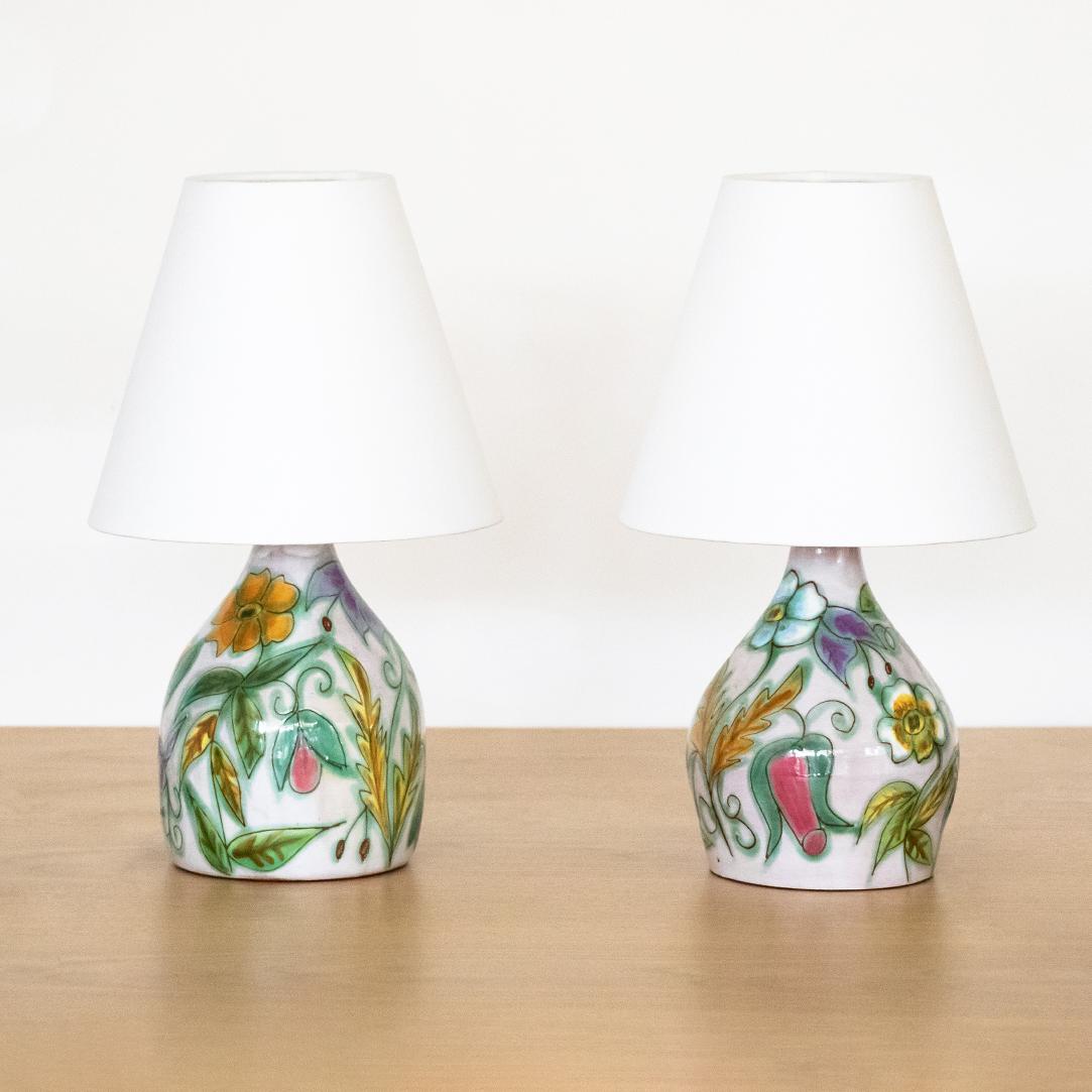 Beautiful pair of ceramic painted lamps from France. Intricate etched floral design painted in vibrant colors. Newly re-wired and new linen shades.