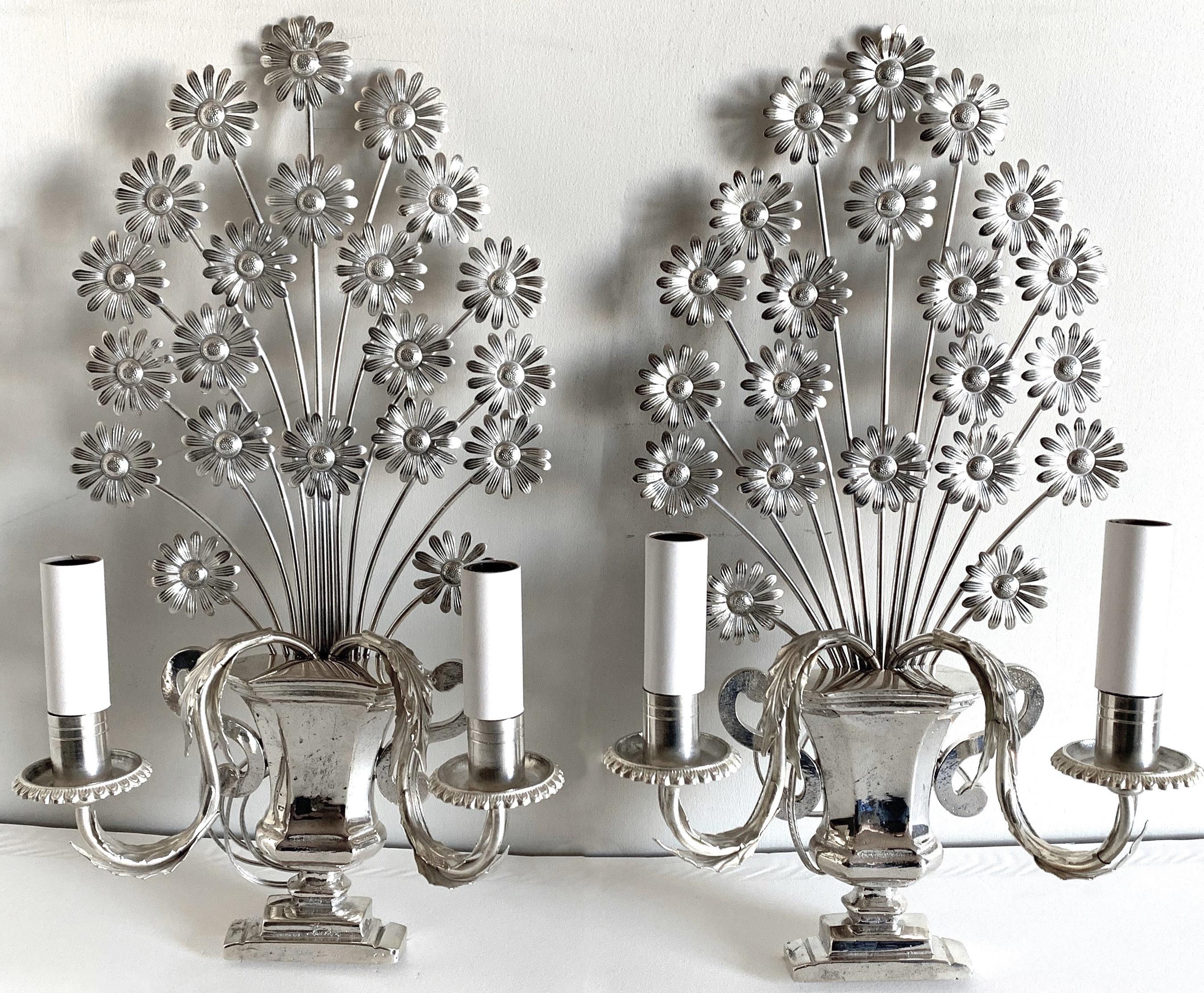Pair of 1950s French metal flower sconces. Newly silver plated and polished. Newly rewired. Each light takes two chandelier bulbs (not included).
Please note that additional components such as back plates may be required for installation and are
