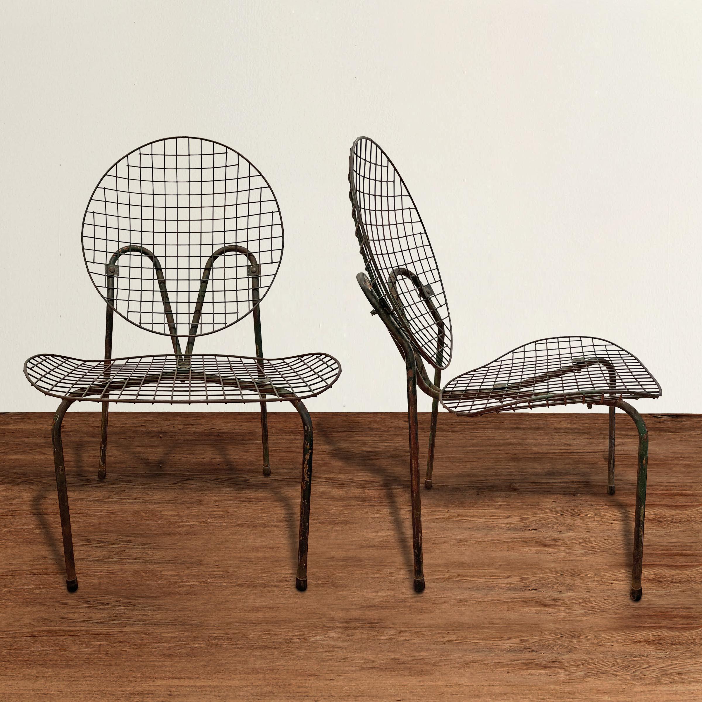 A chic and sculptural pair of early 20th century French garden chairs with bent tubular frames and wide wire mesh backs and seats. Chairs are perfectly comfortable as they are, but they would be beautiful with custom cushions as well. Also work