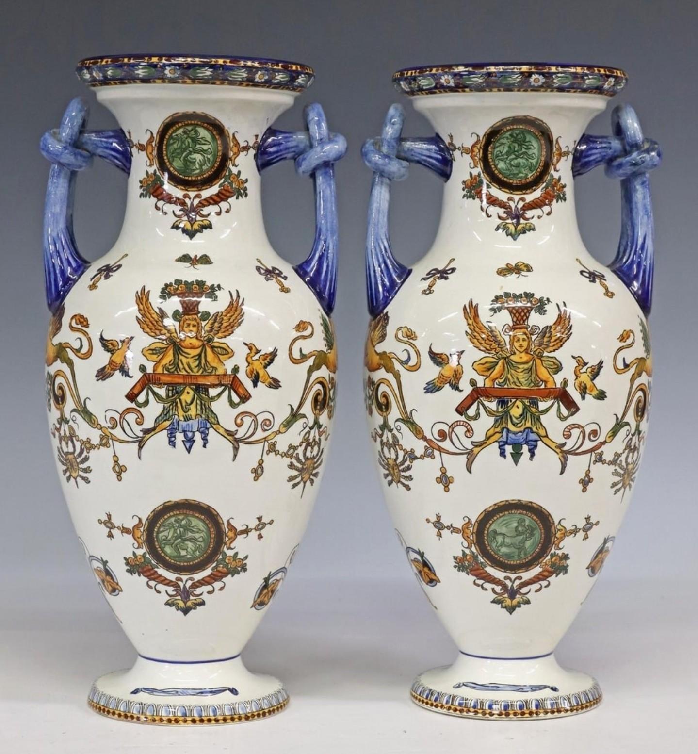 A remarkable pair of French faience earthenware vases by Faïencerie de Gien, likely late 19th century, double handled flared baluster amphora form, richly detailed, with fine hand painted decoration in the classic Italian Renaissance style. Cream -