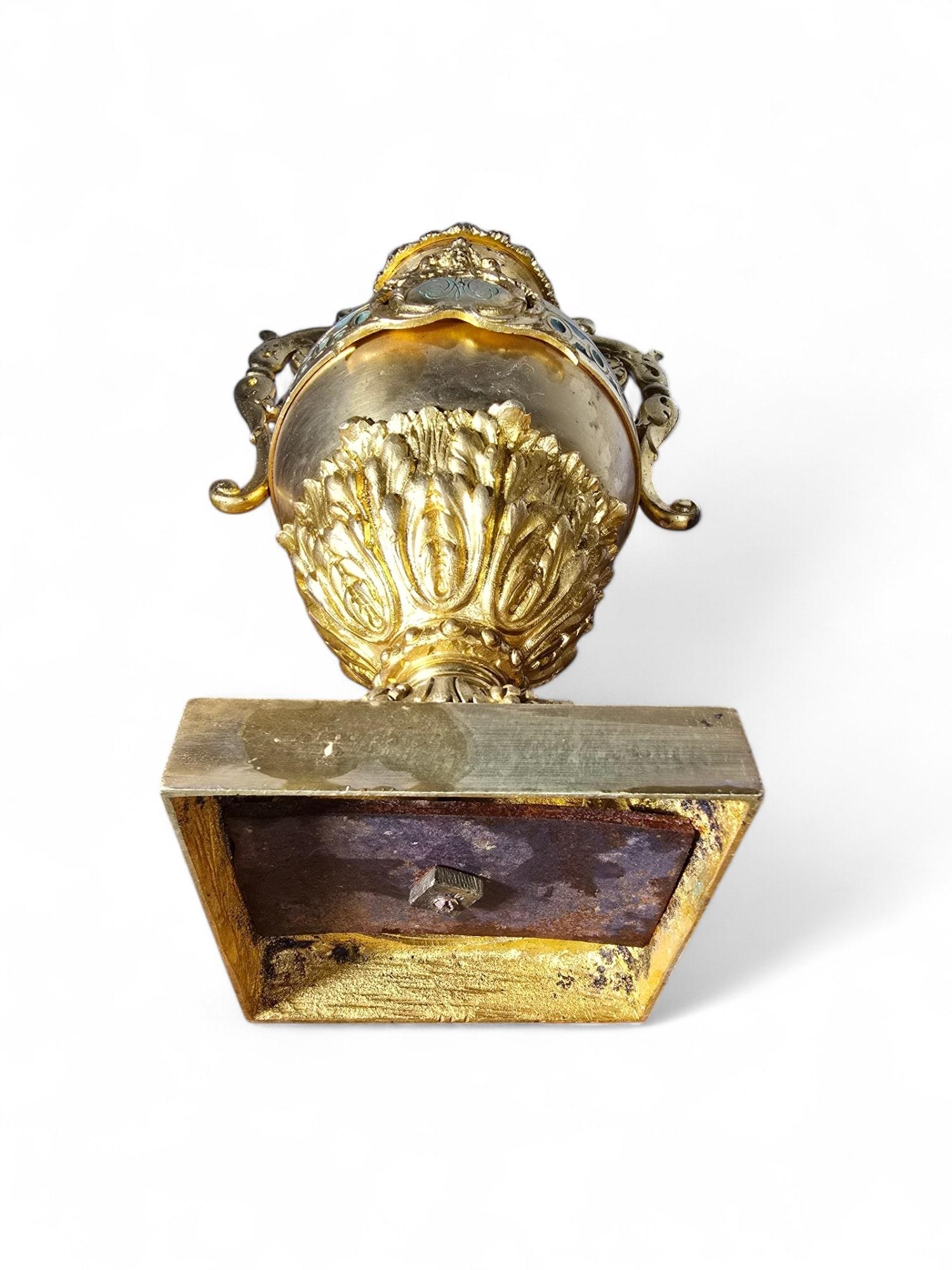 A decorative pair of French vases crafted in gilded bronze and adorned with turquoise-green enamel. These elegant pieces feature a combination of bright and matte mercury gilding for a striking visual effect, and each vase is embellished with a