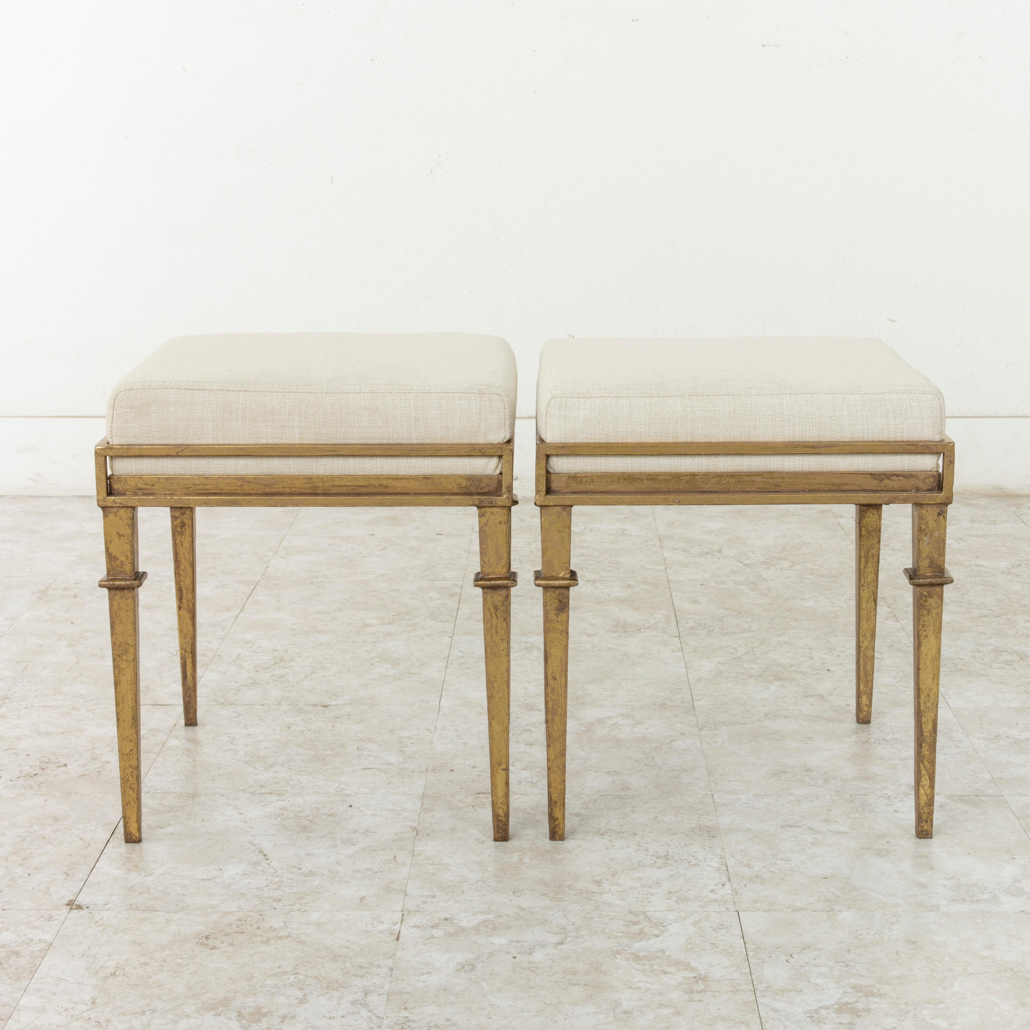 An original creation by a contemporary French designer, this pair of gilded iron banquettes or benches features a Louis XVI inspired base with tapered square legs. Newly upholstered in France in linen. Sold as a pair.