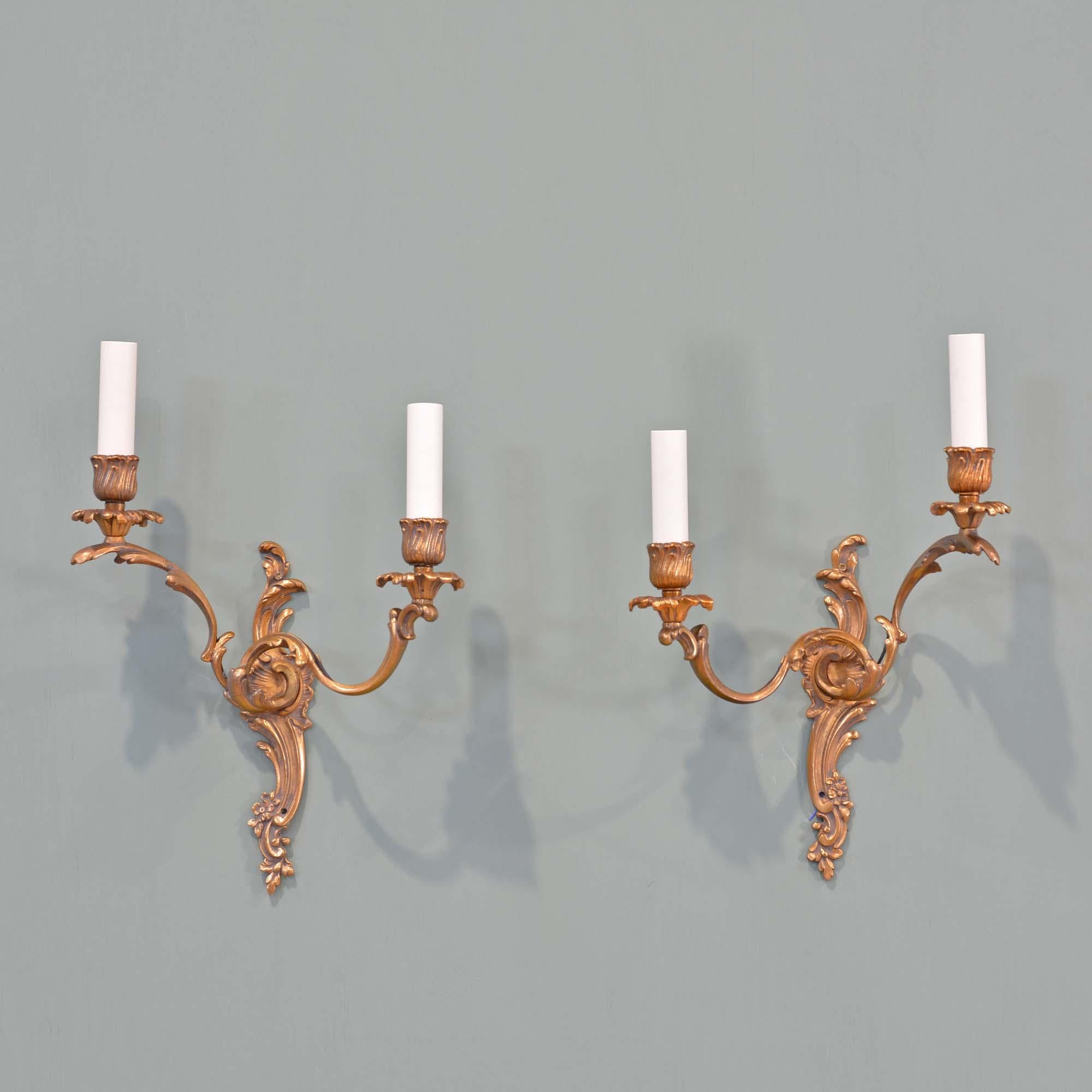 Paire d'appliques Rococo en laiton doré
Luminaires à deux bras en laiton doré de style rococo, une paire de miroirs avec des plaques murales à rinceaux en S, des bobèches et des bougeoirs.
Français, vers 1930

Recâblage et installation de nouveaux