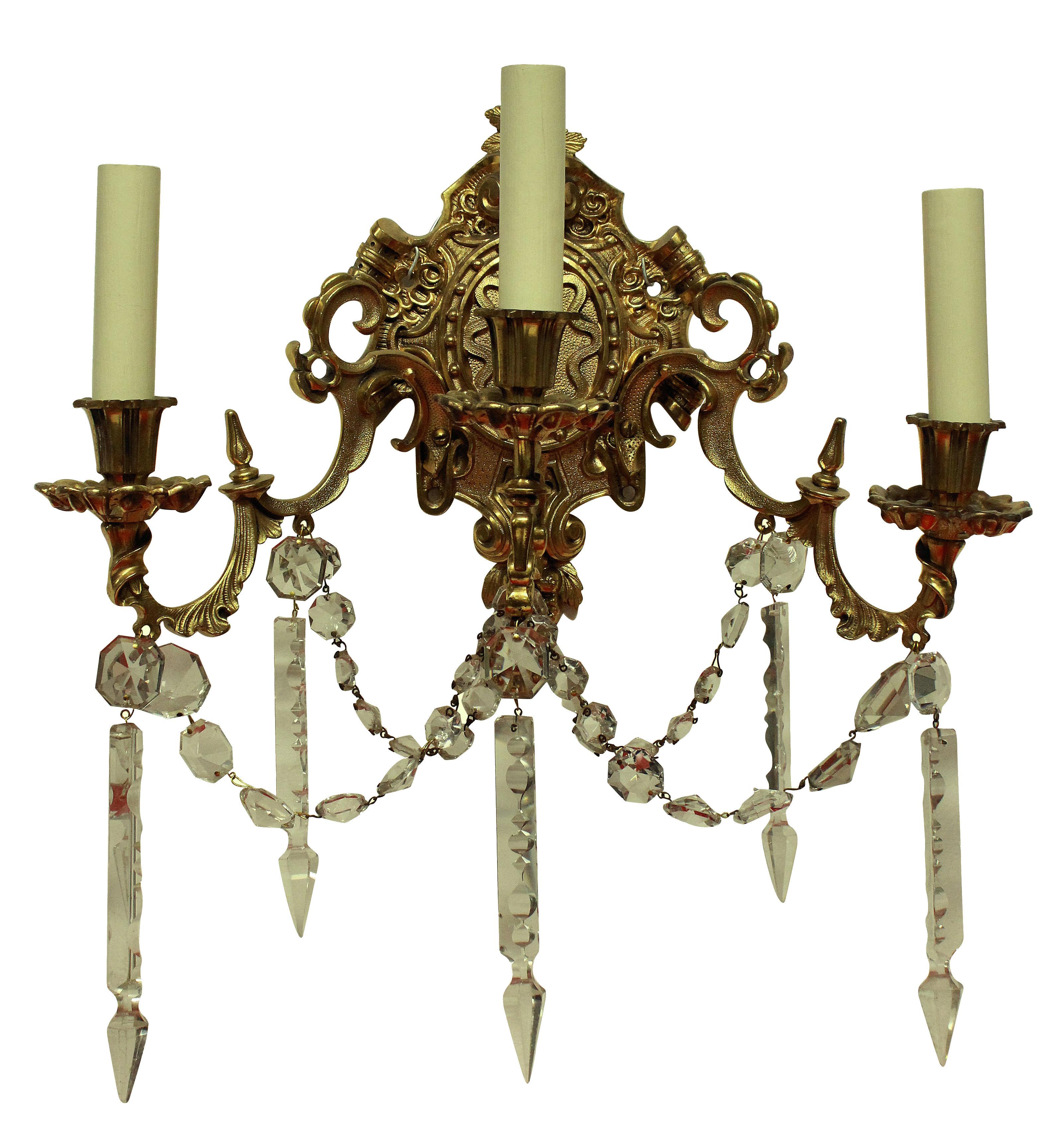 A pair of French Napoleon III gilt bronze, three branch wall lights hung with cut-glass.