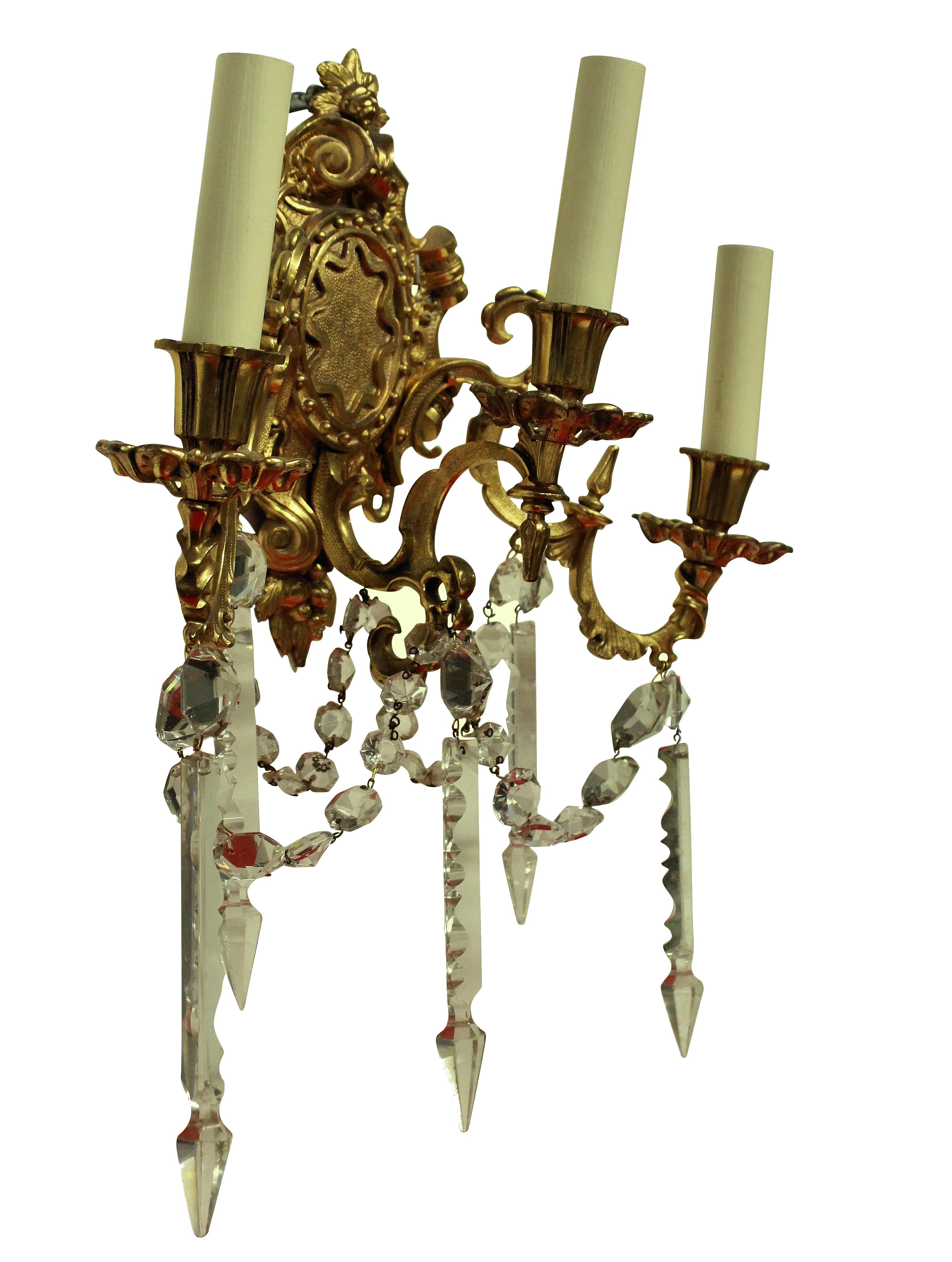 A pair of French Napoleon III gilt bronze, three branch wall lights hung with cut-glass.