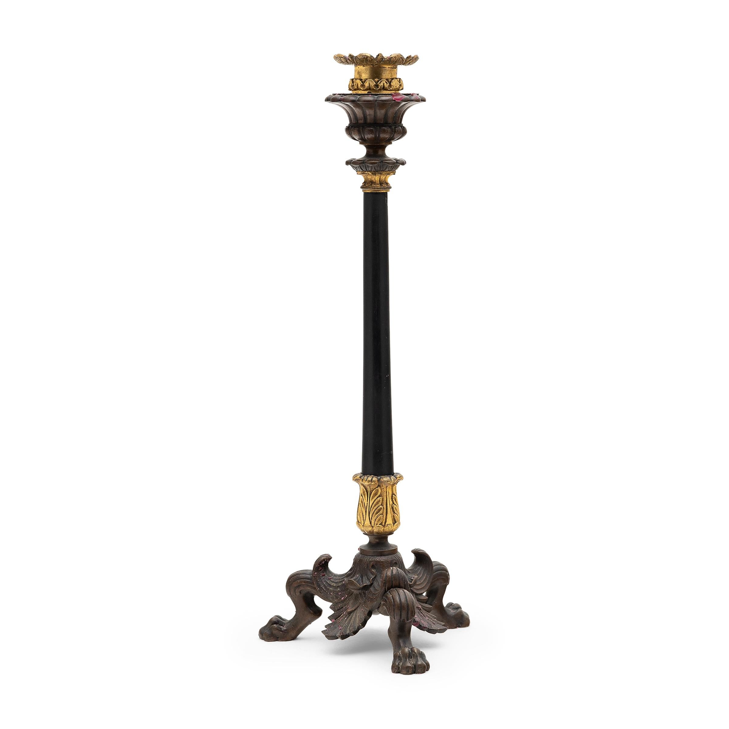 This regal pair of bronze and slate candlesticks originated in 19th-century France and are beautifully detailed with molded and gilt embellishments. Crafted in the style of Empire furniture, each candlestick rests on a triform bronze base of claw
