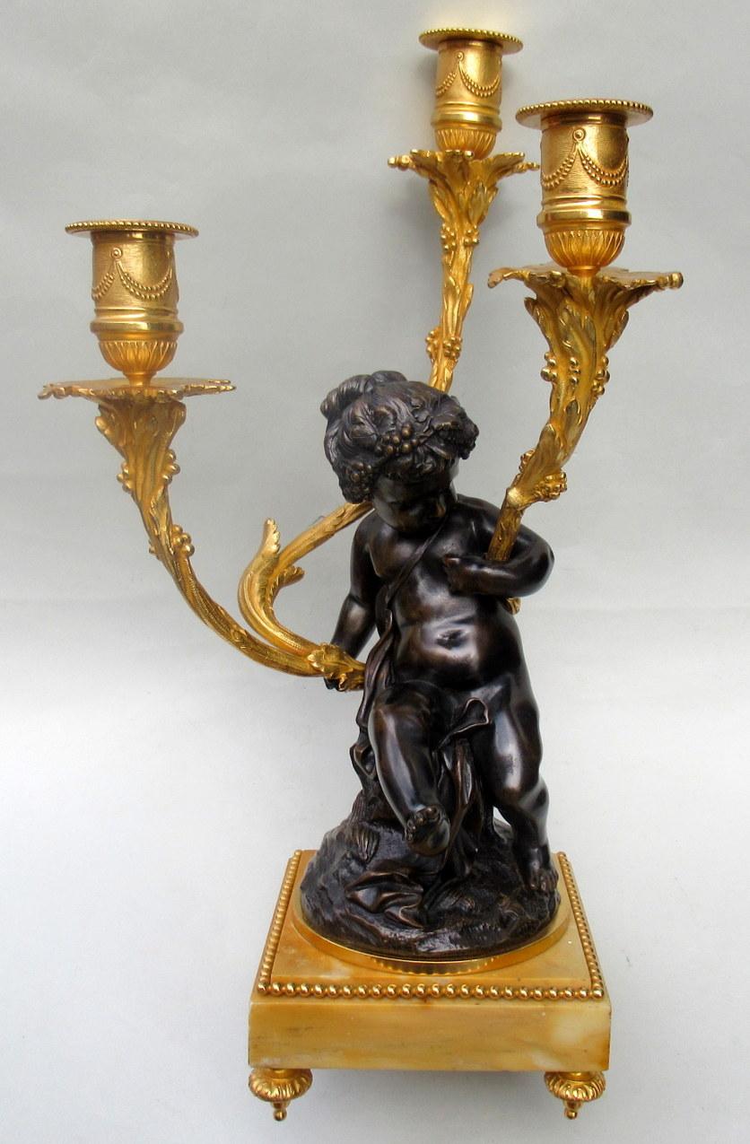 A very fine quality pair of French Louis XV inspired patinated and gilt bronze figural three branch candelabra depicting Bacchanal figures. Both with finely sculped features and mounted atop naturalistically modelled bronze bases, made during the