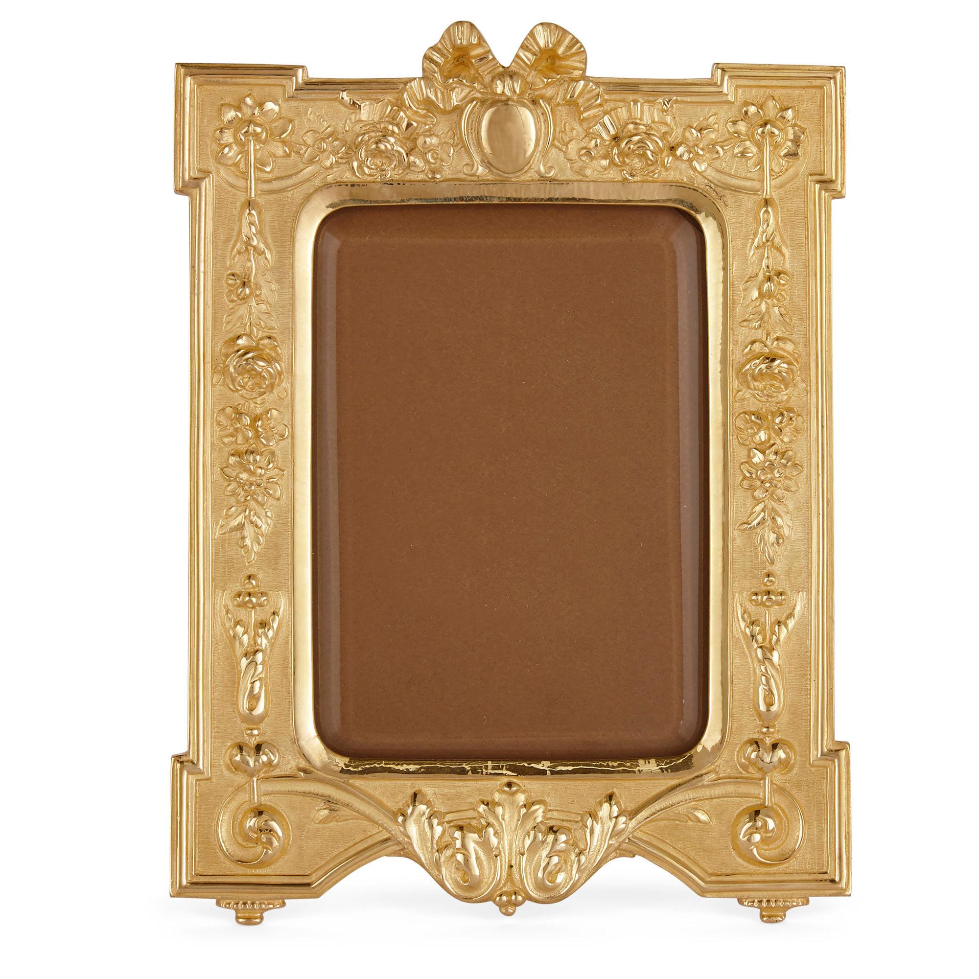 Pair of French gilt bronze photograph frames in the Neoclassical style
French, early 20th century
Measures: Height 22cm, width 16.5cm, depth 2cm

These superb photograph frames are designed in the Neoclassical manner from gilt bronze. The